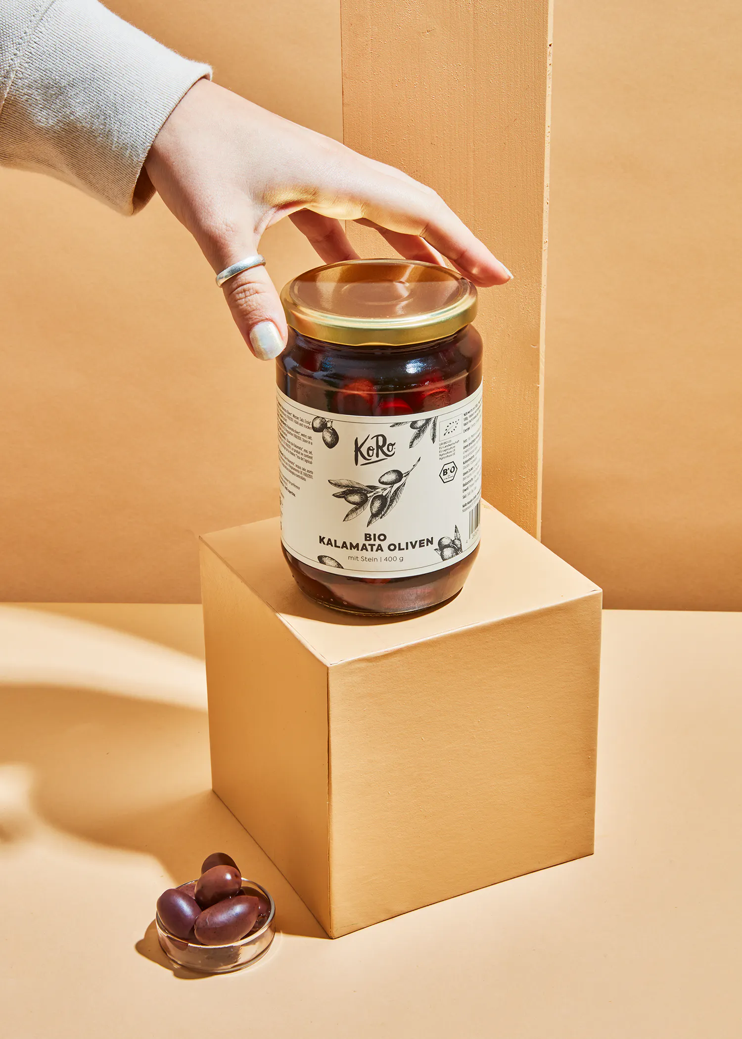 une personne tient un bocal de kalamata olives bio