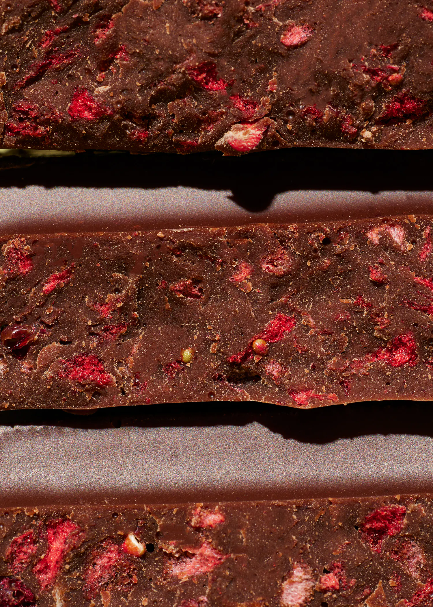 un gros plan d' une barre de chocolat avec des fraises sur elle