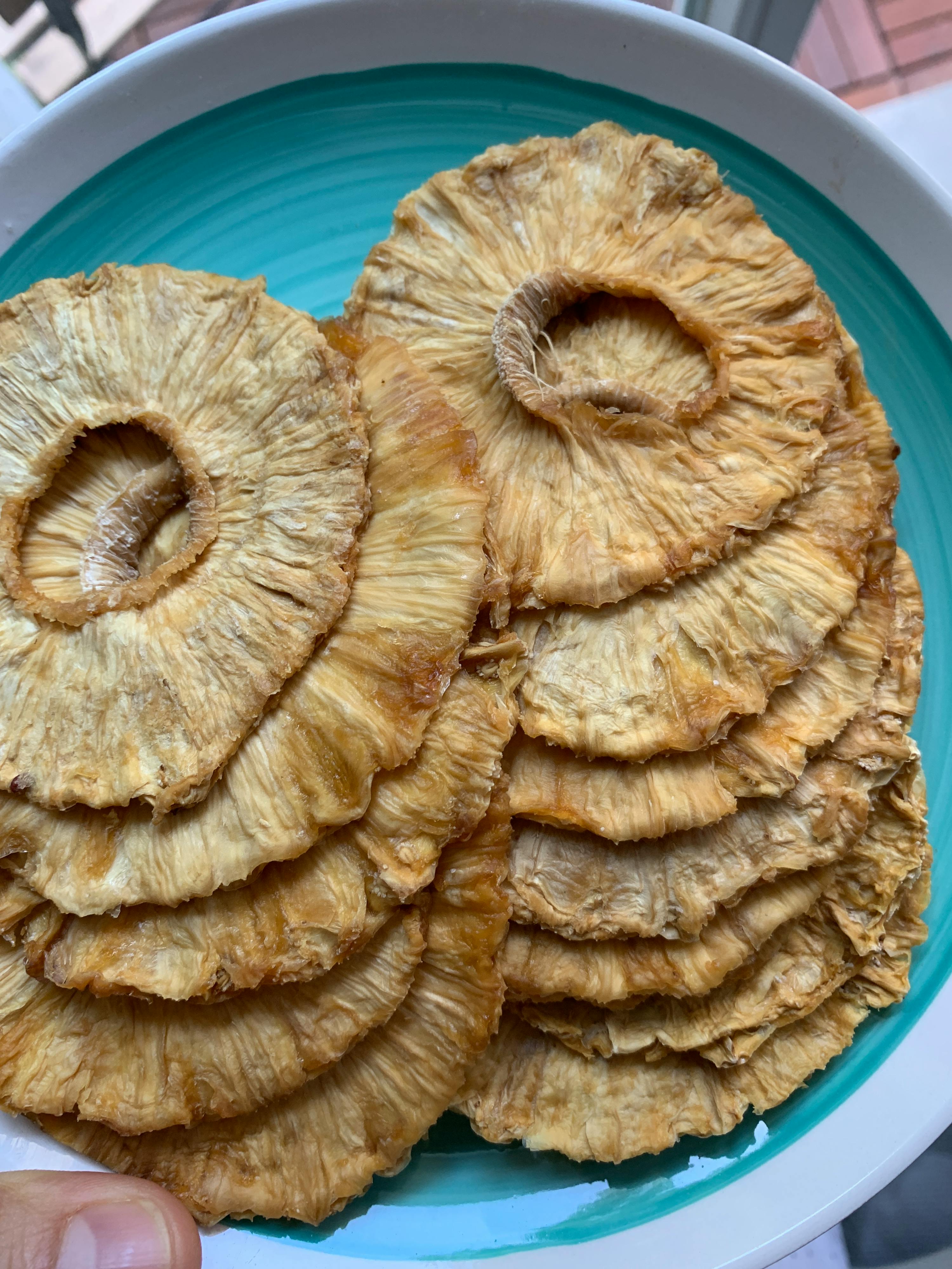 a plate of pineapple slices on a blue and white plate