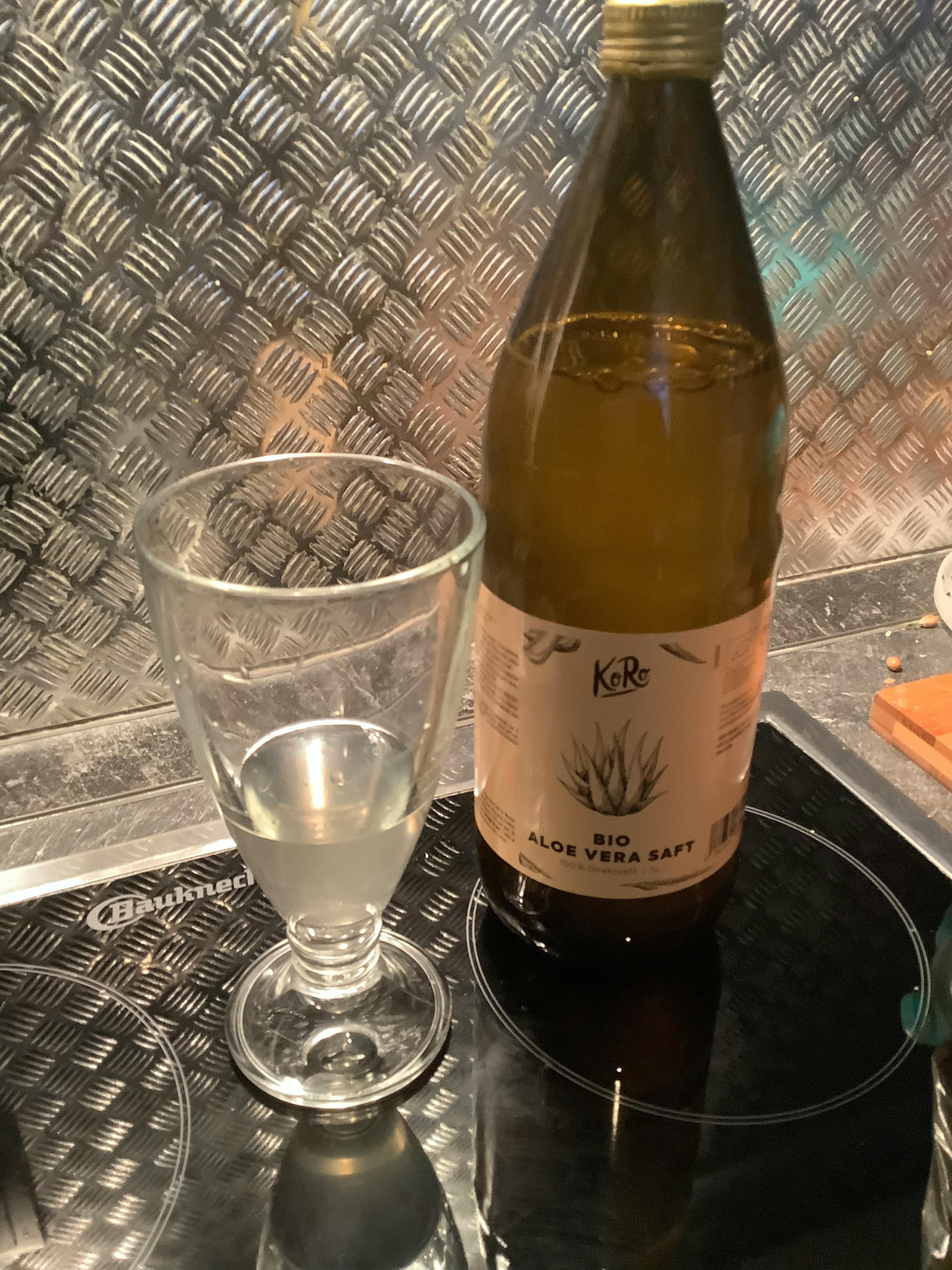 a bottle of krc aloe vera soft next to a glass