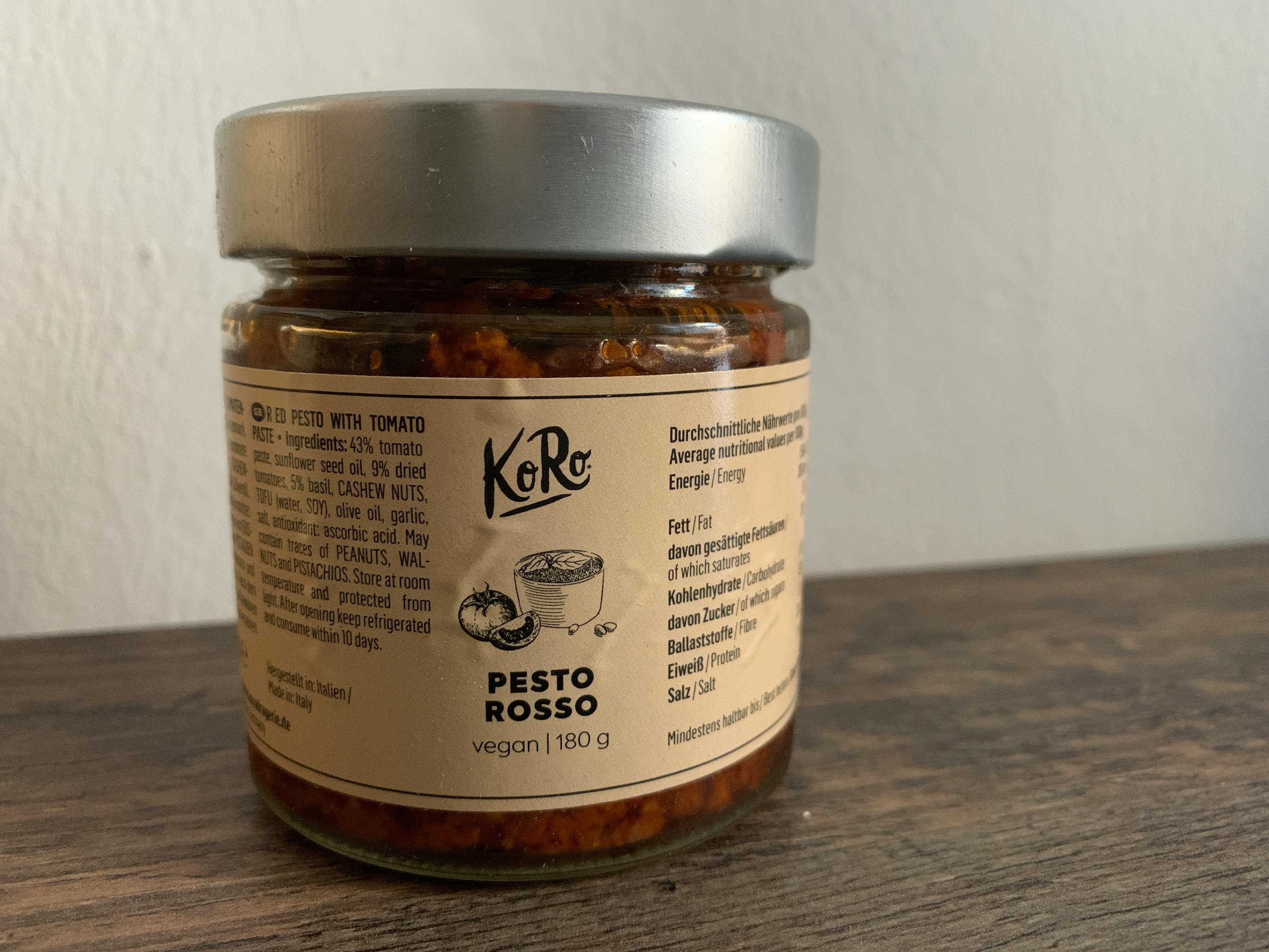 un barattolo di pesto rosso è su un tavolo di legno