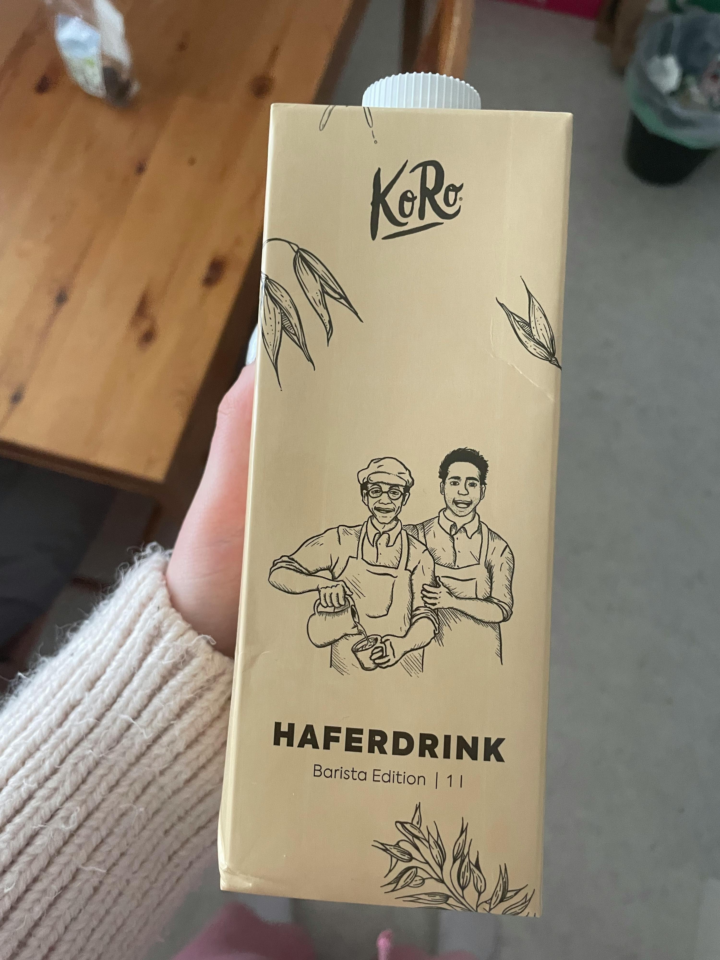 a person holding a carton of haferdrink barista edition