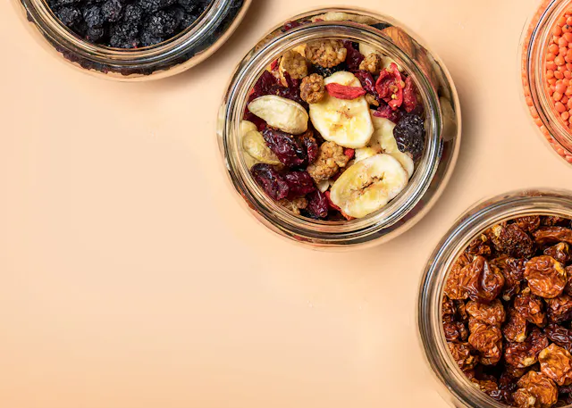 three jars of dried fruits and nuts on a table