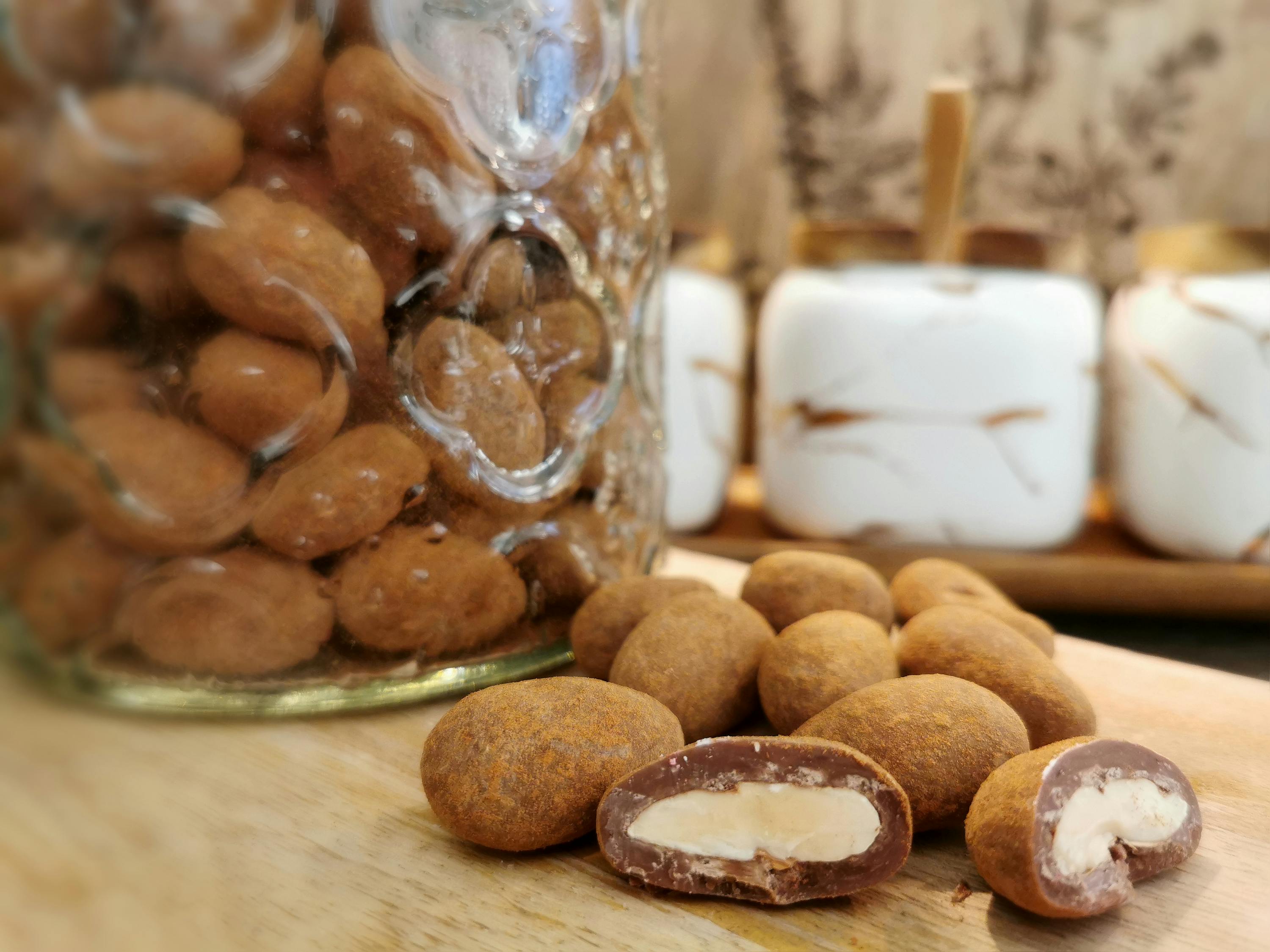 eine Nahaufnahme von Schokoladenbedeckten Erdnüssen auf einem Holztisch