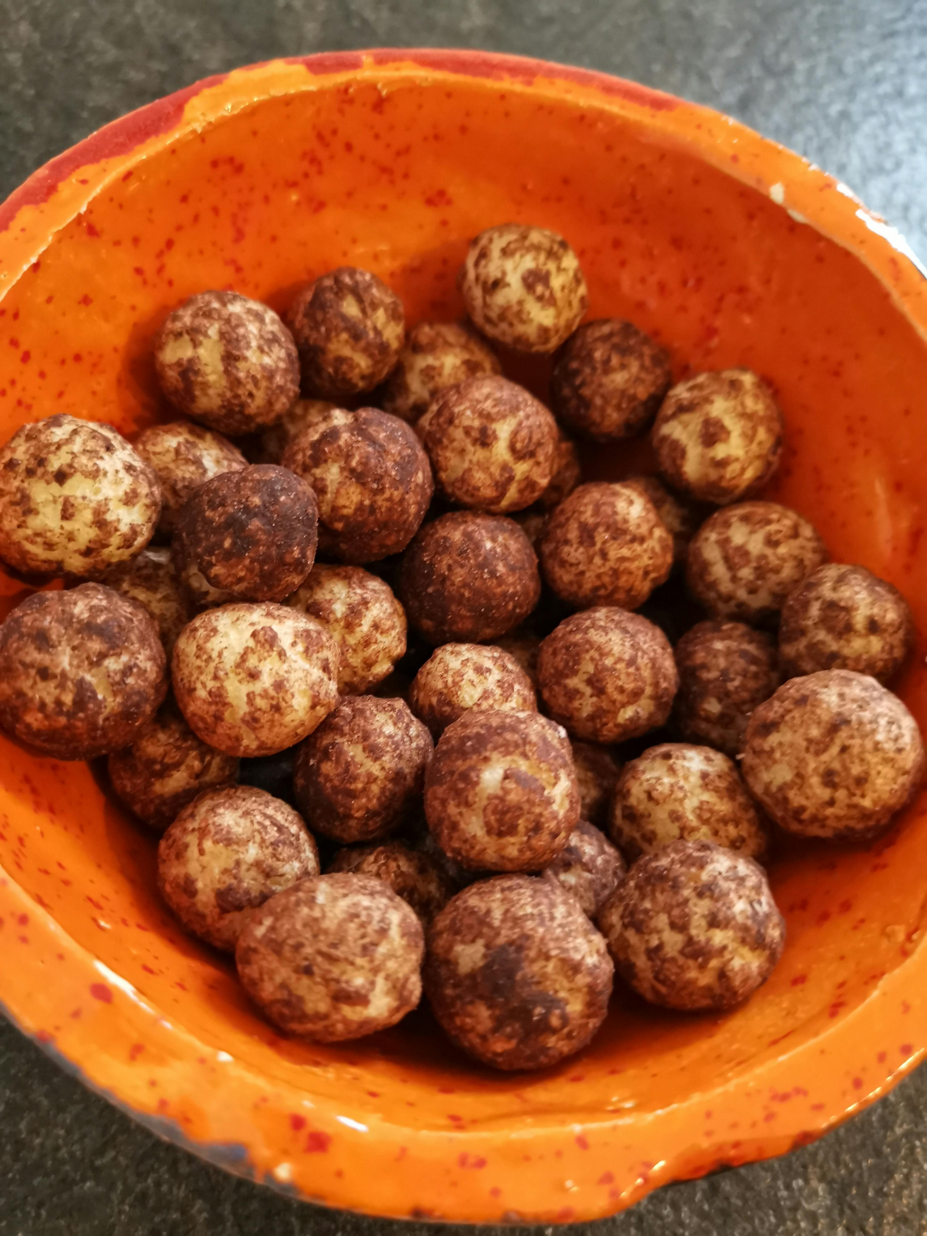 eine Nahaufnahme einer orangefarbenen Schüssel mit Schokoladenkugeln