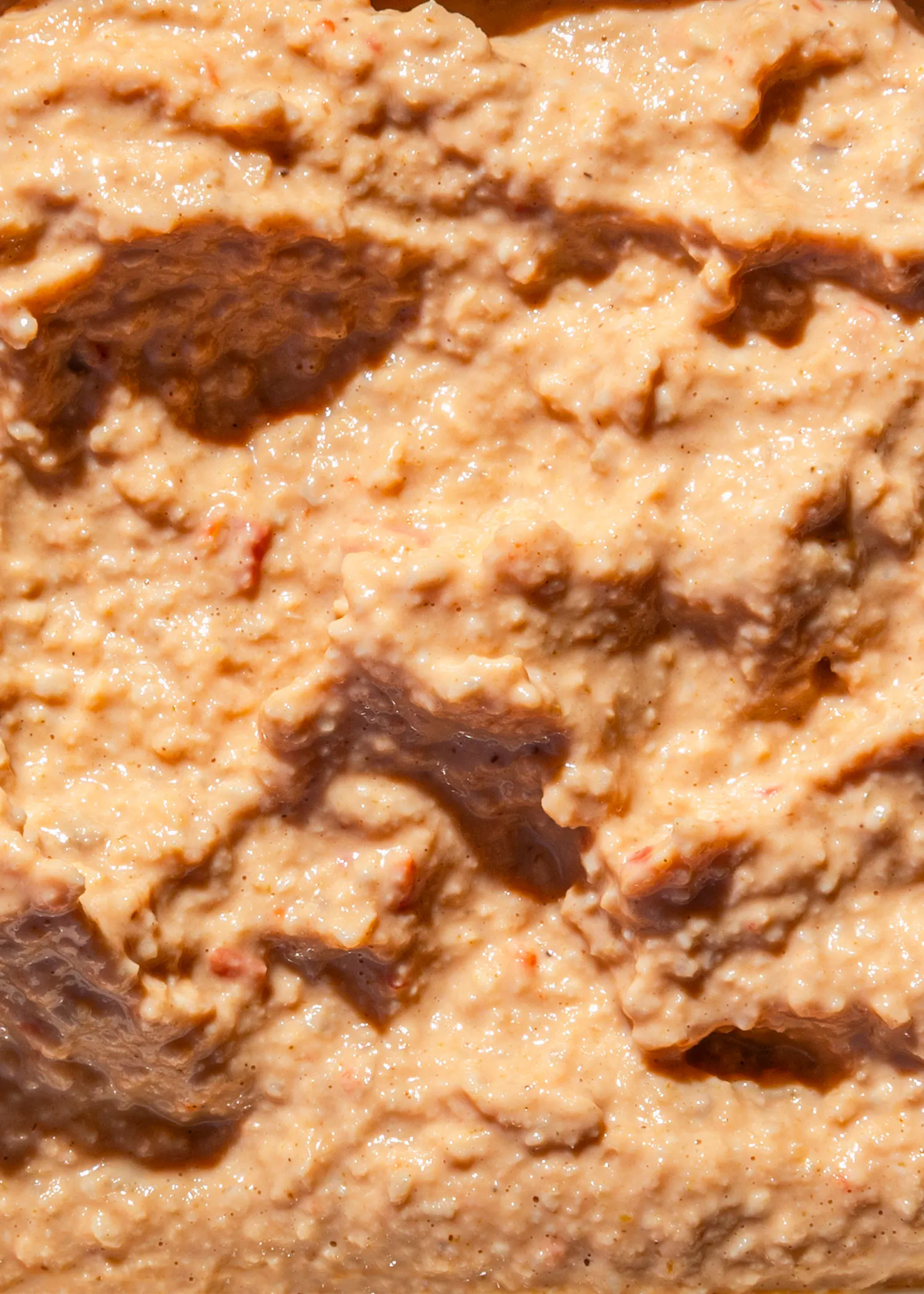 a close up of a creamy sauce with a brown stripe on the bottom