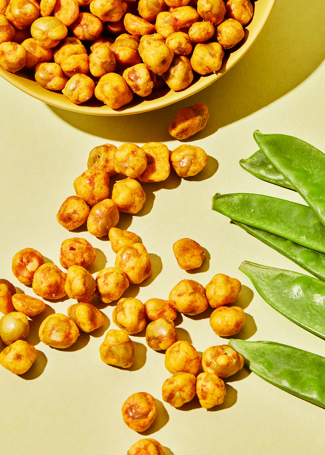 eine Schüssel mit gerösteten Kichererbsen neben einem Haufen gerösteter Kichererbsen