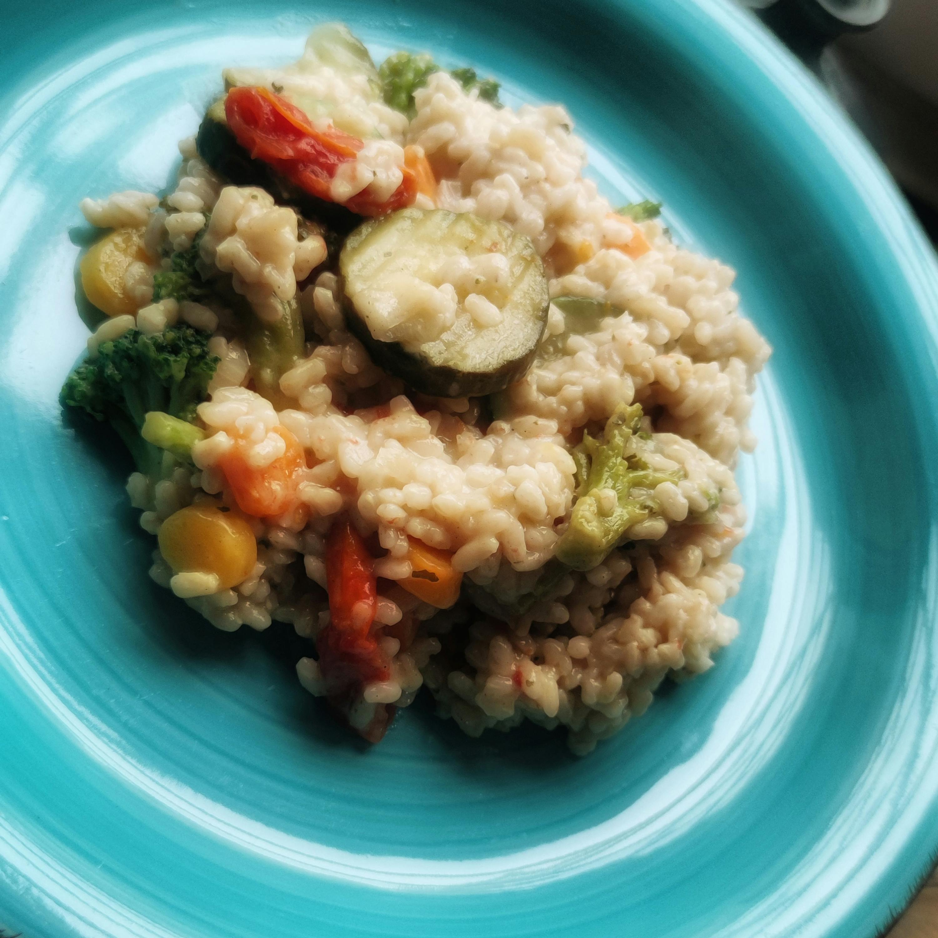 une assiette bleue avec du riz et des légumes sur elle