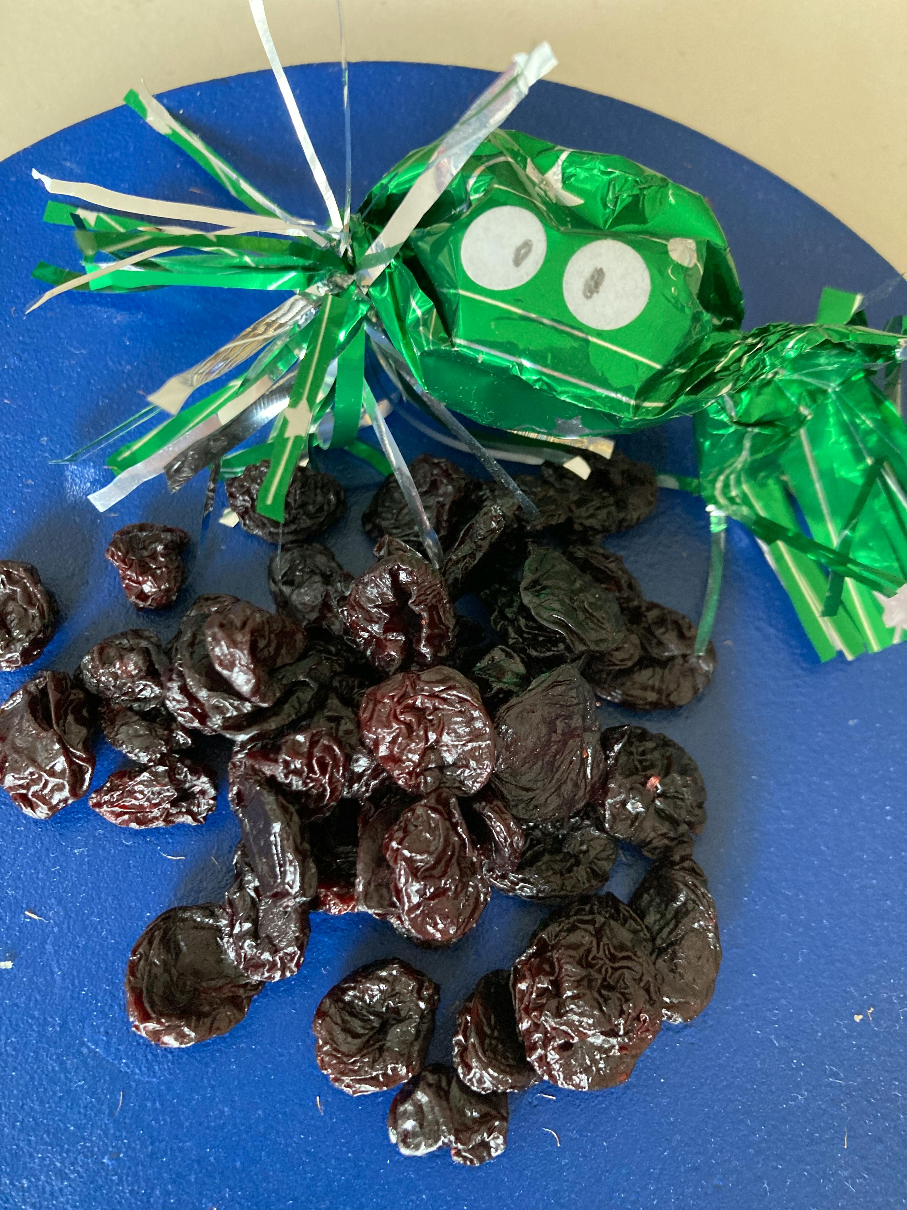 un tas de prunes noires sur une planche à découper bleue