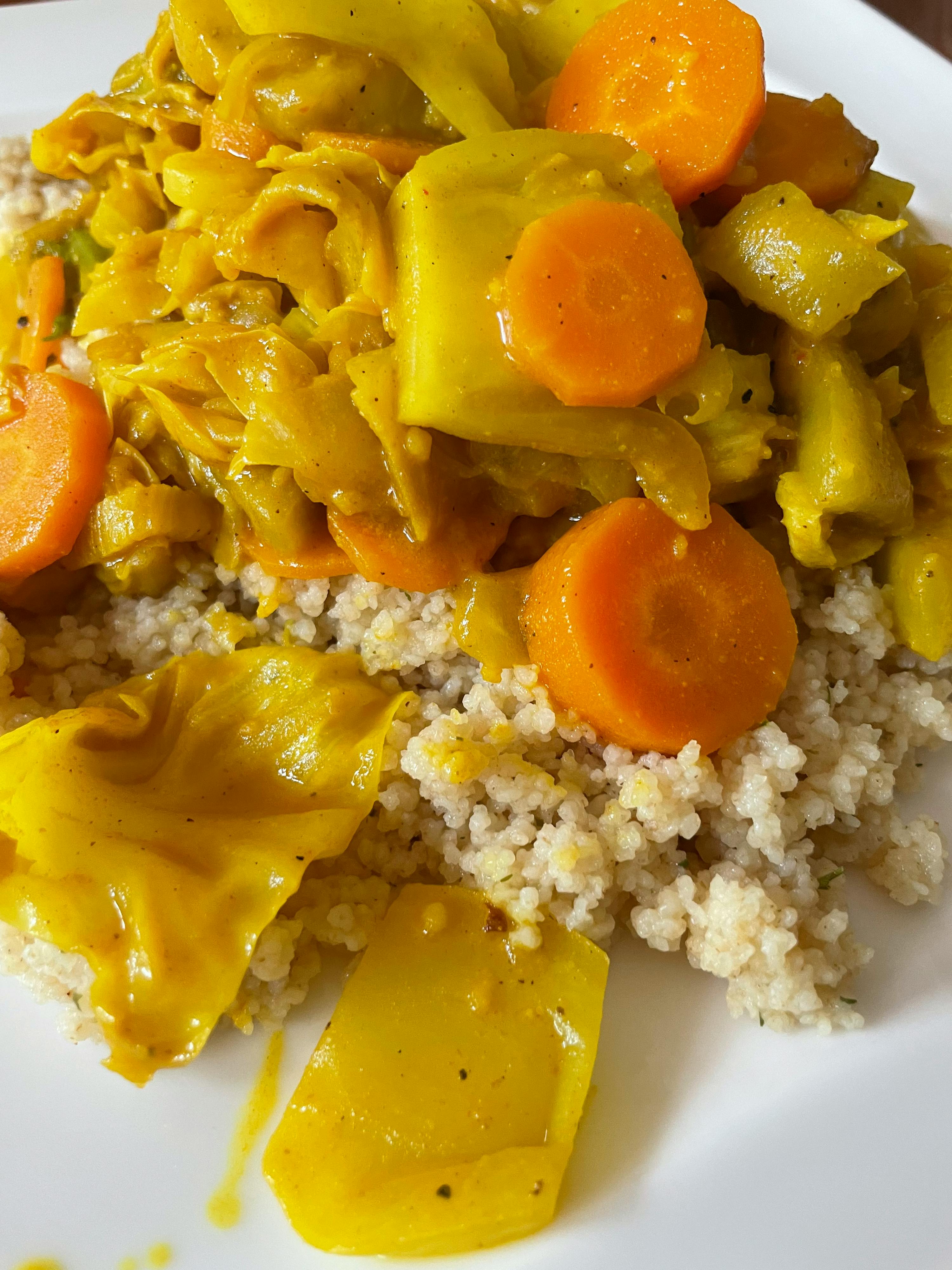 ein Teller mit Gemüse und Reis auf einem Tisch