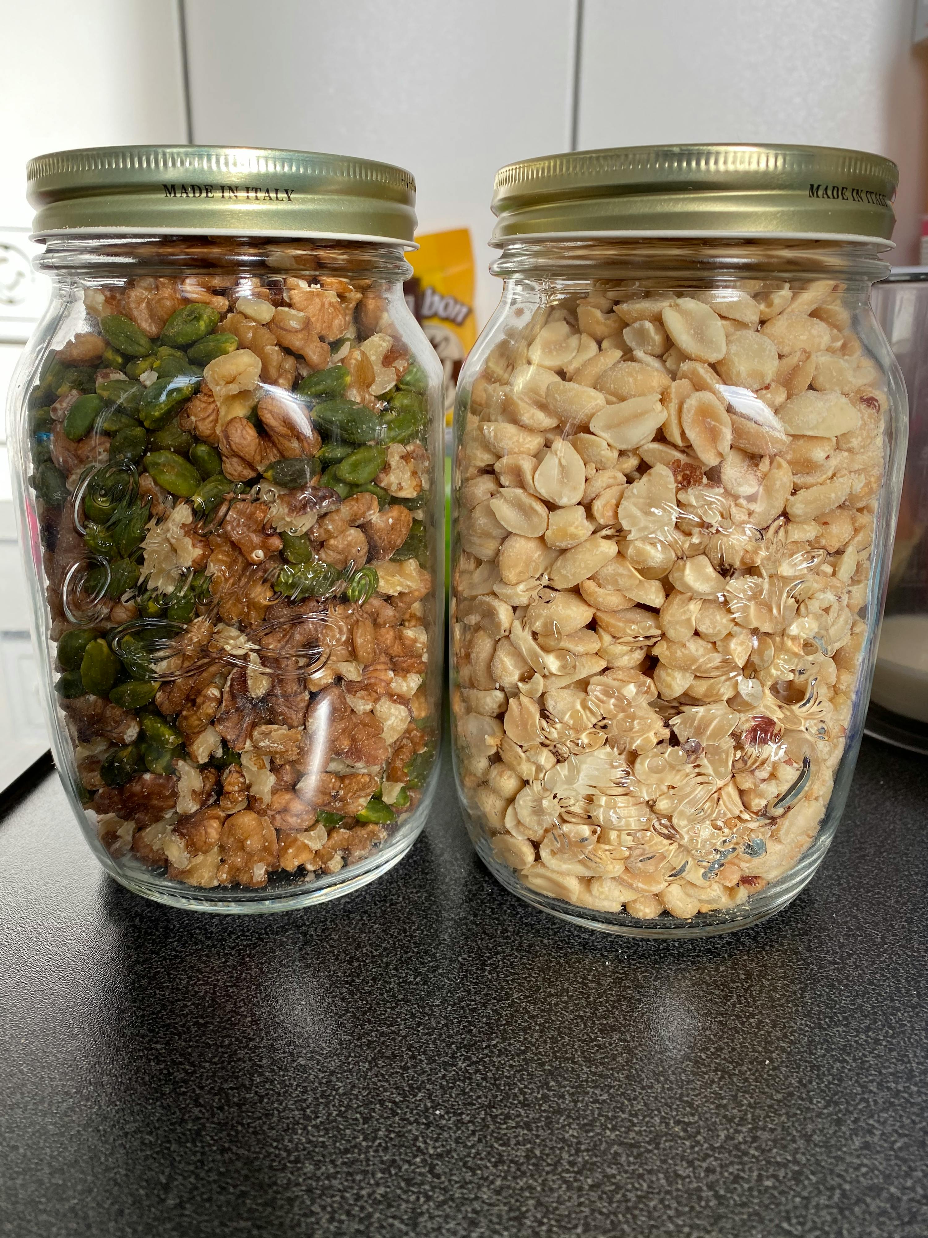 zwei Gläser mit Erdnüssen und Walnüssen auf einem Tisch