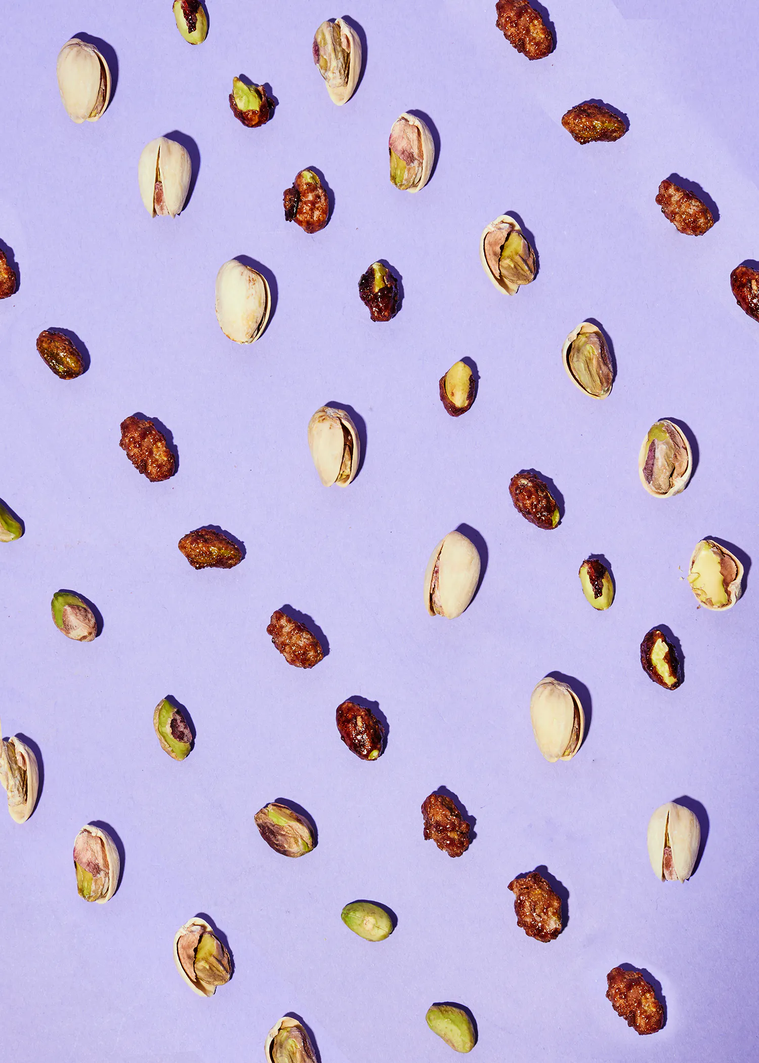 un motif de pistaches et de noix sur un fond violet