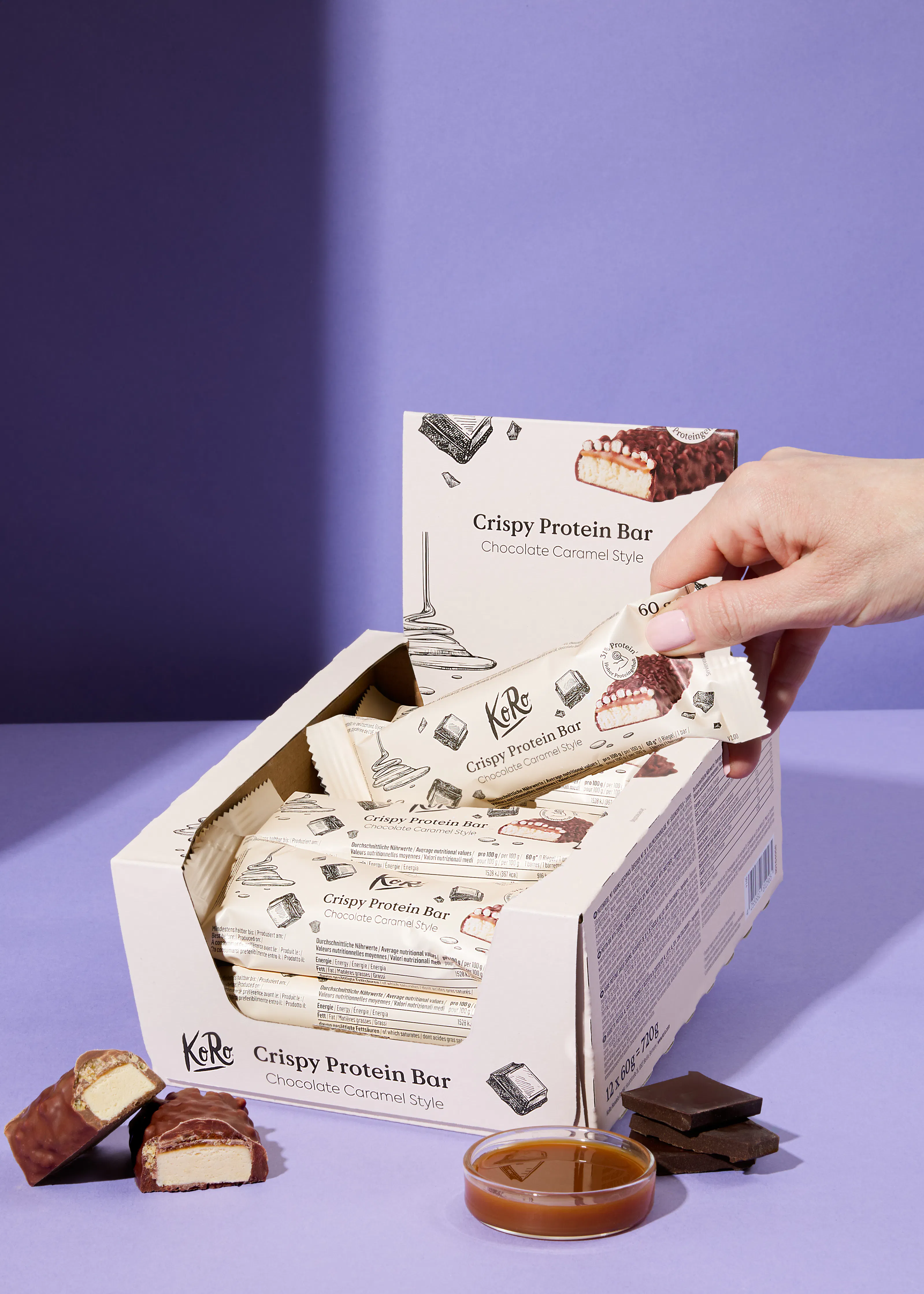 a box of kore crispy protein bars with a hand reaching for one