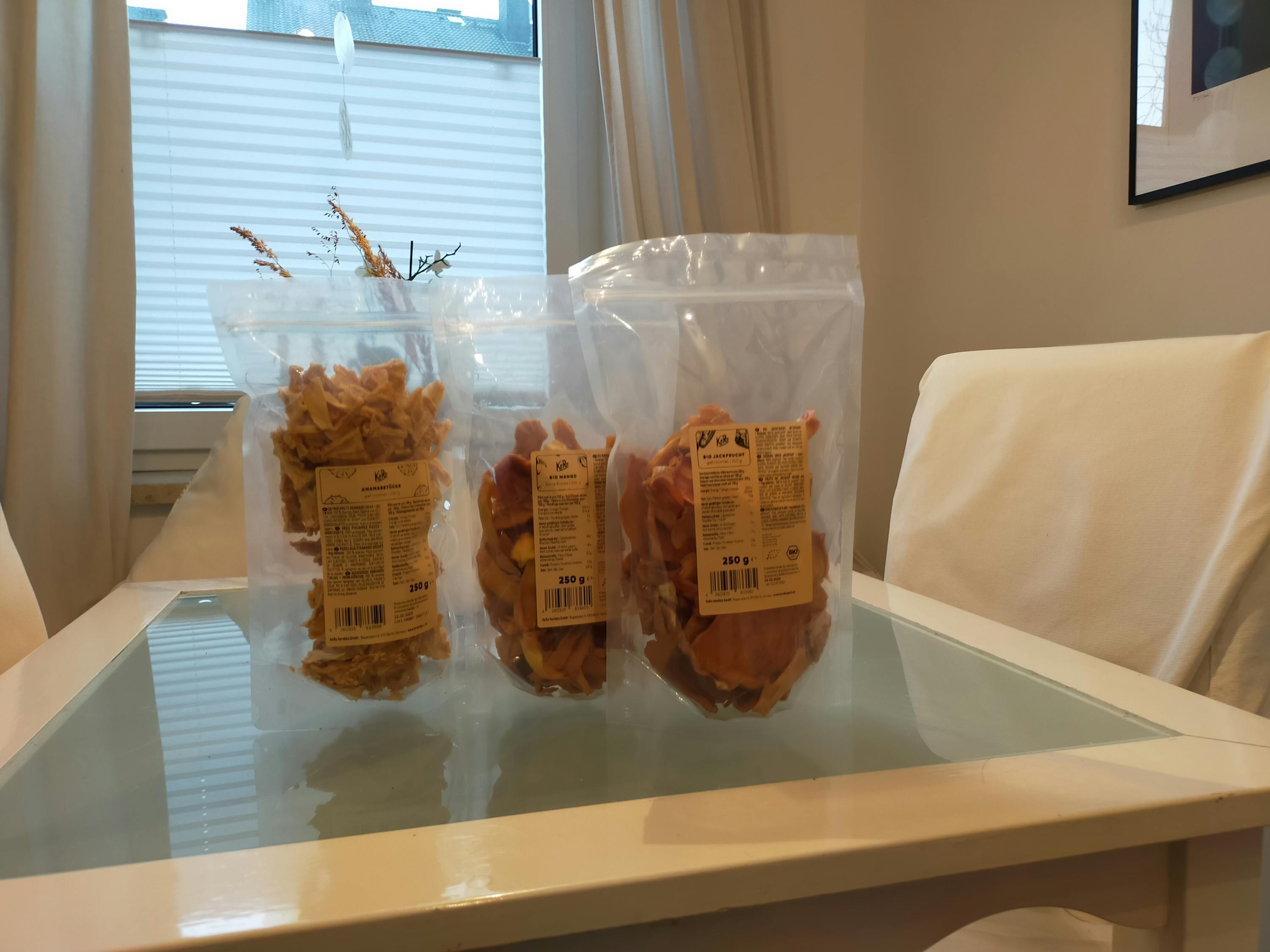 drei Plastiktüten mit trockenfrüchten stehen auf einem Tisch