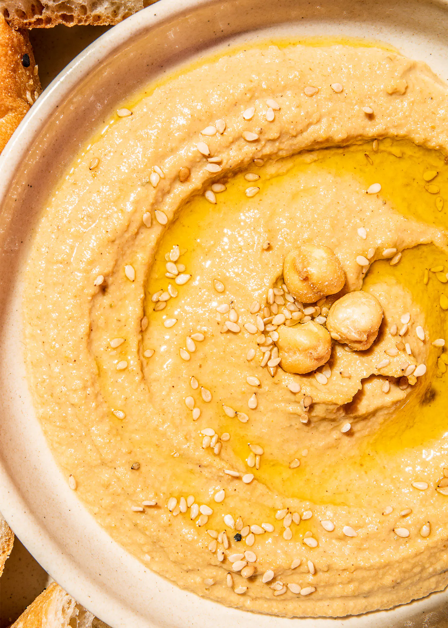 un bol de hummus avec des graines de sésame et de l' huile