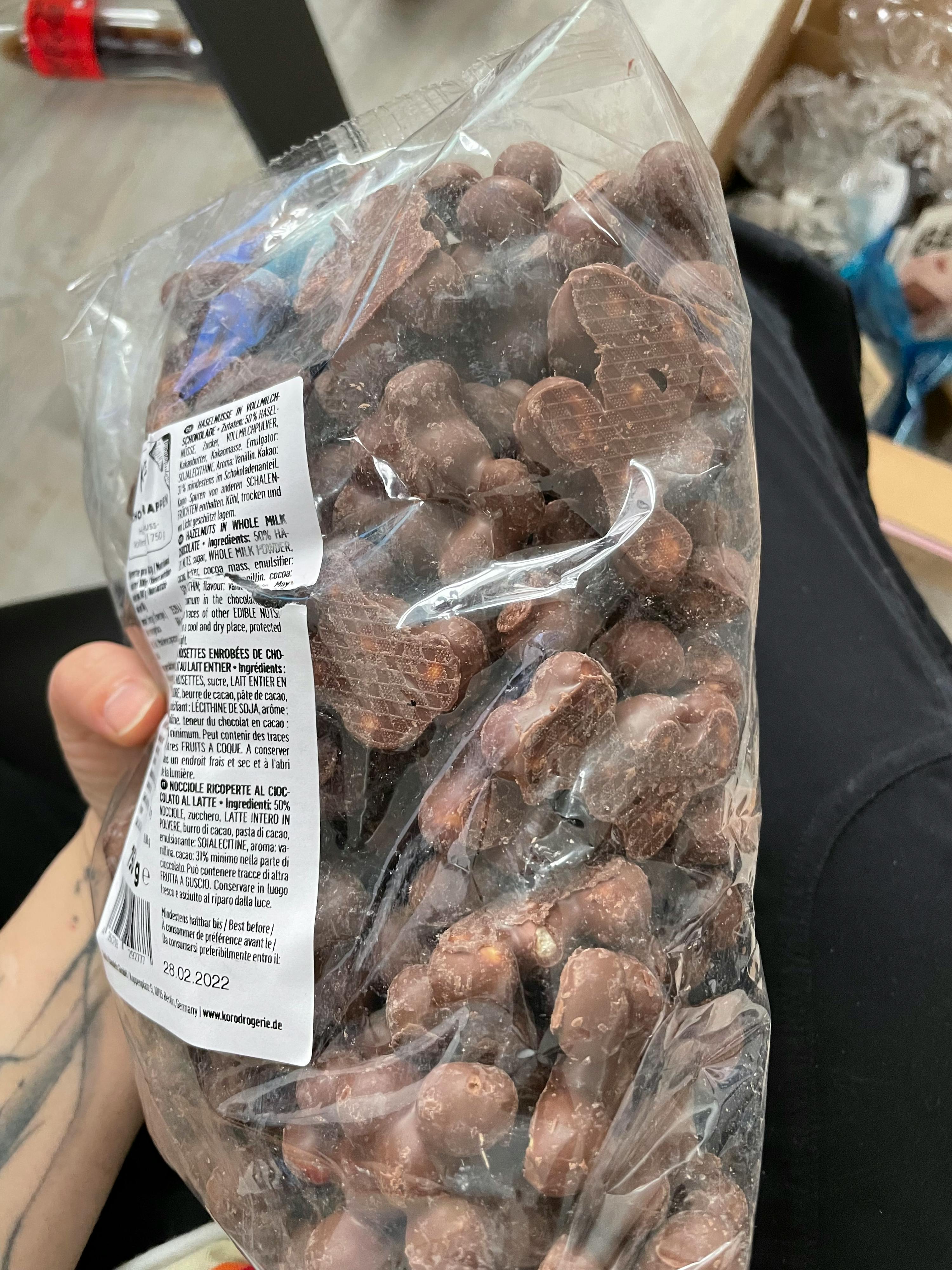 Eine Person hält einen Plastikbeutel mit Schokoladenstückchen in der Hand