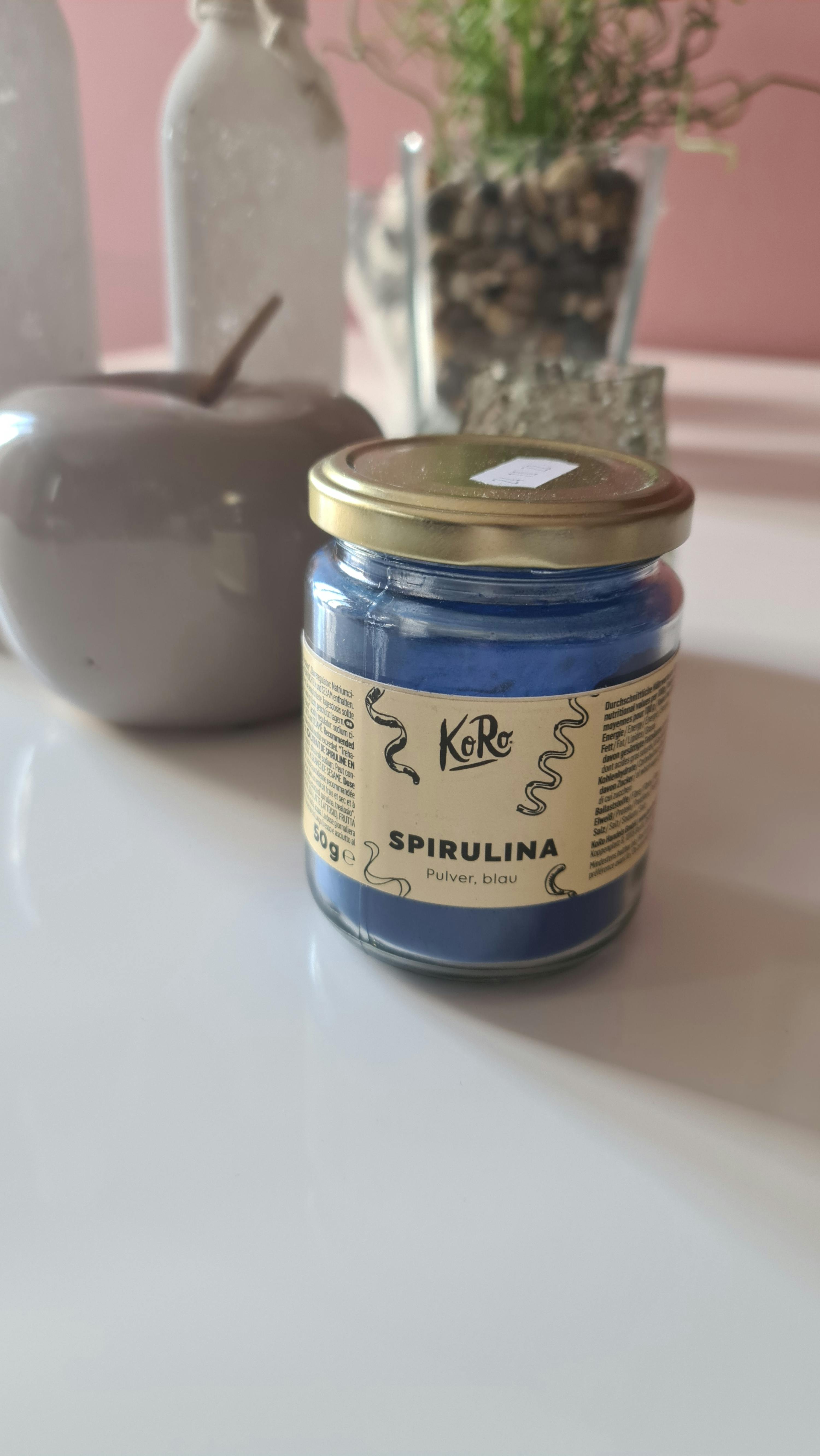 un barattolo di spirulina blu è seduto su un tavolo