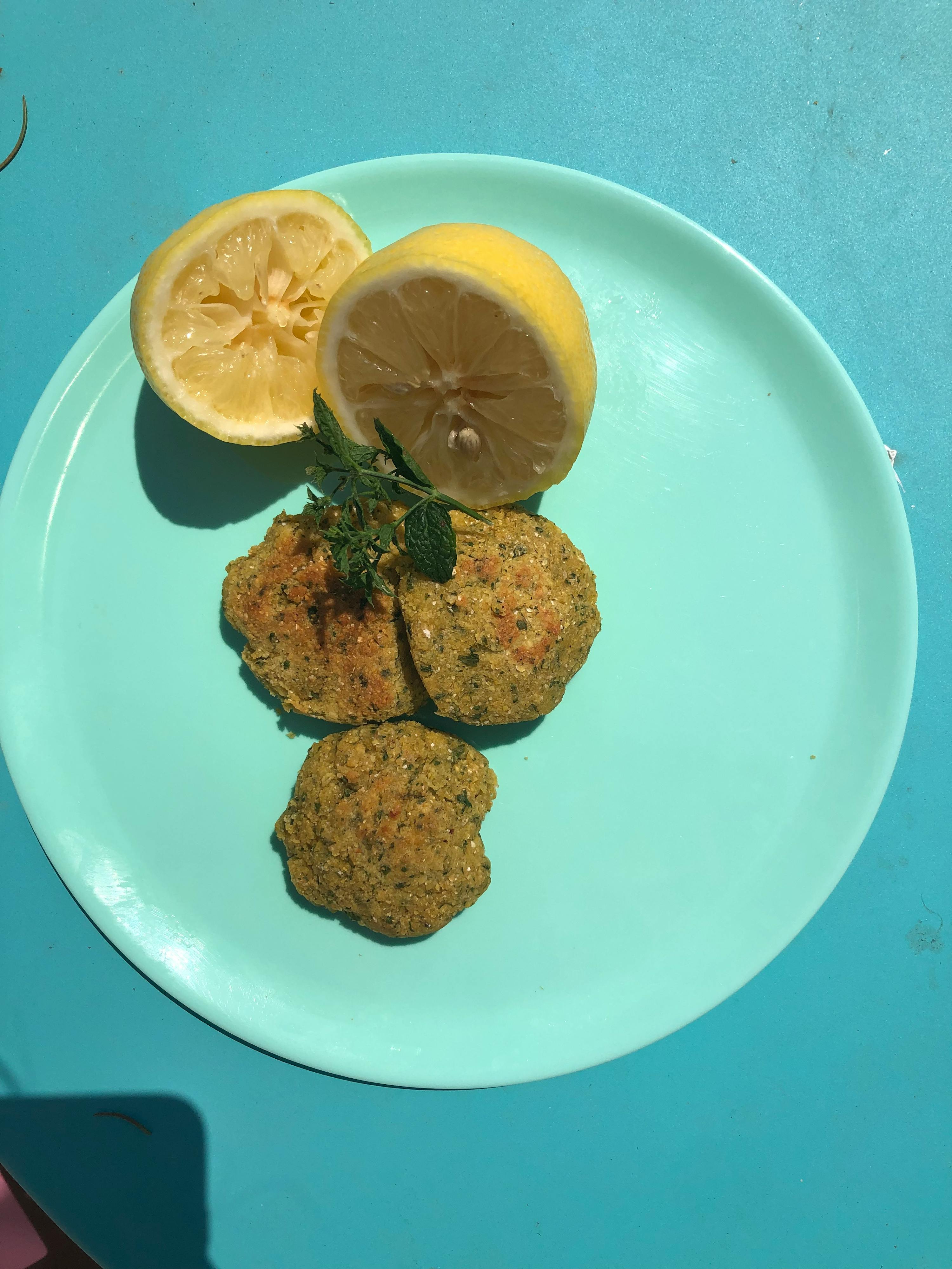 ein blauer Teller mit drei Keksen und einer Zitronenscheibe