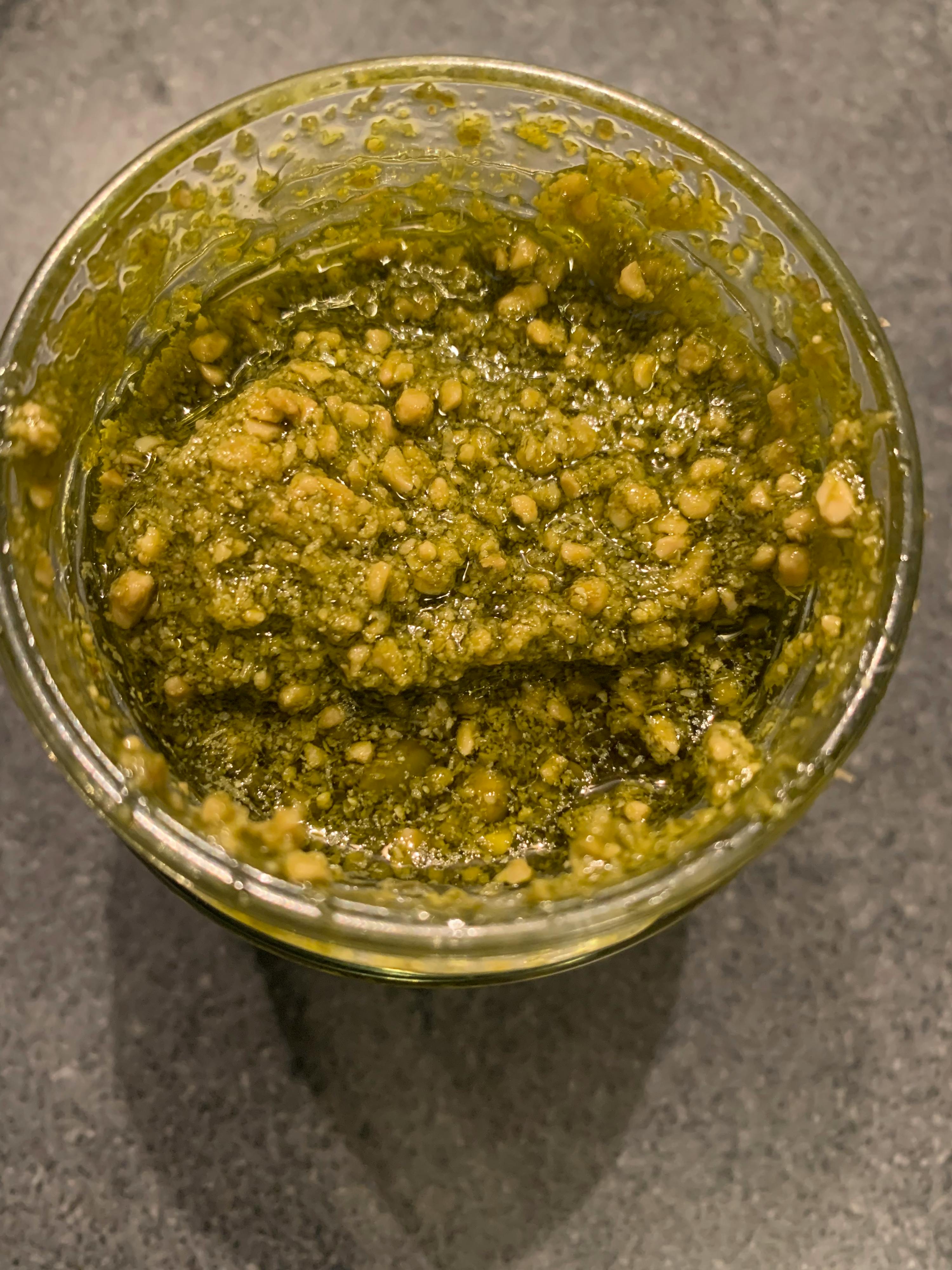 eine Nahaufnahme eines Glases mit einer grünen Soße