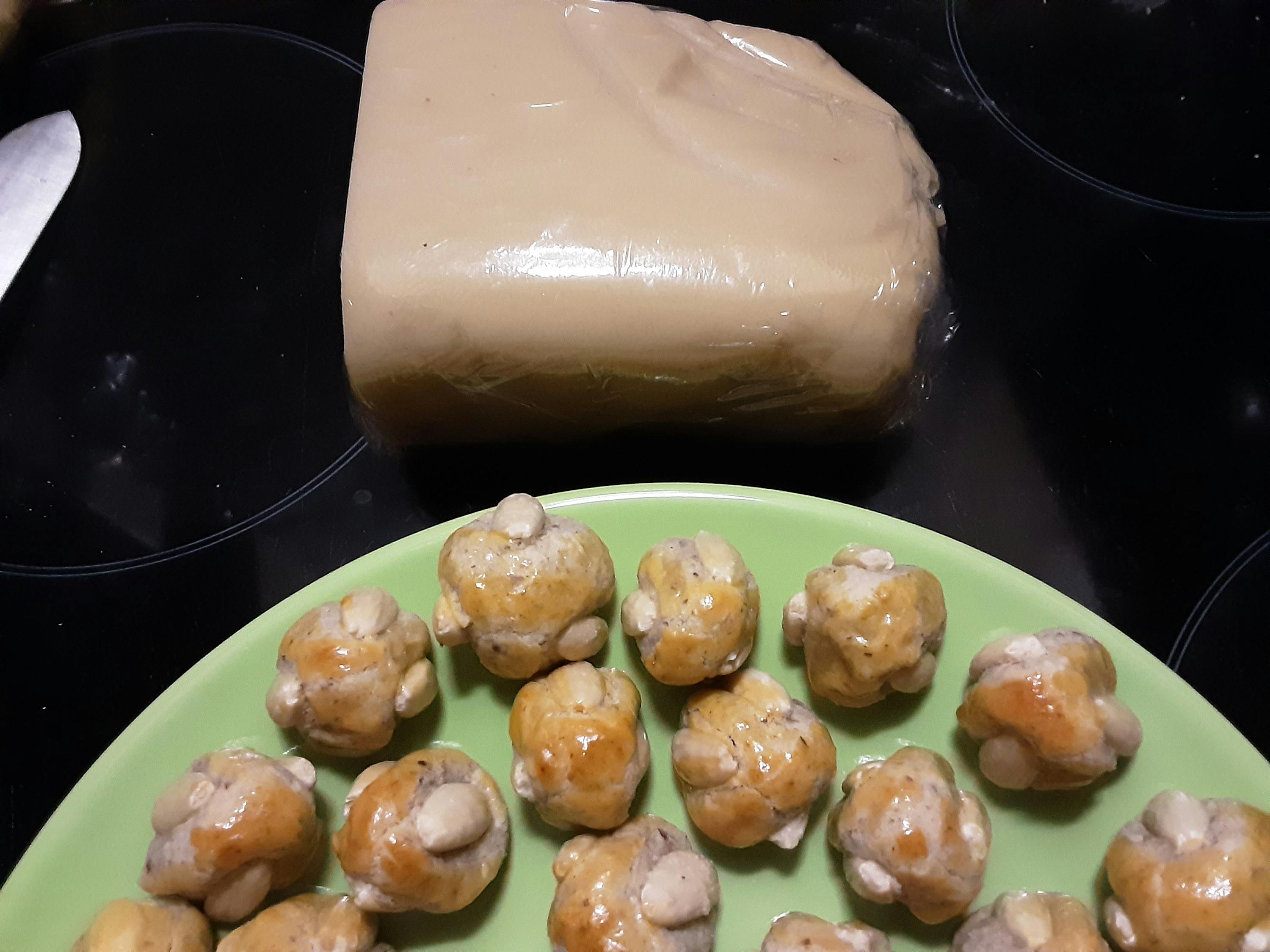 un gros morceau de pâte est posé sur une table à côté d' une assiette verte remplie de petits gâteaux