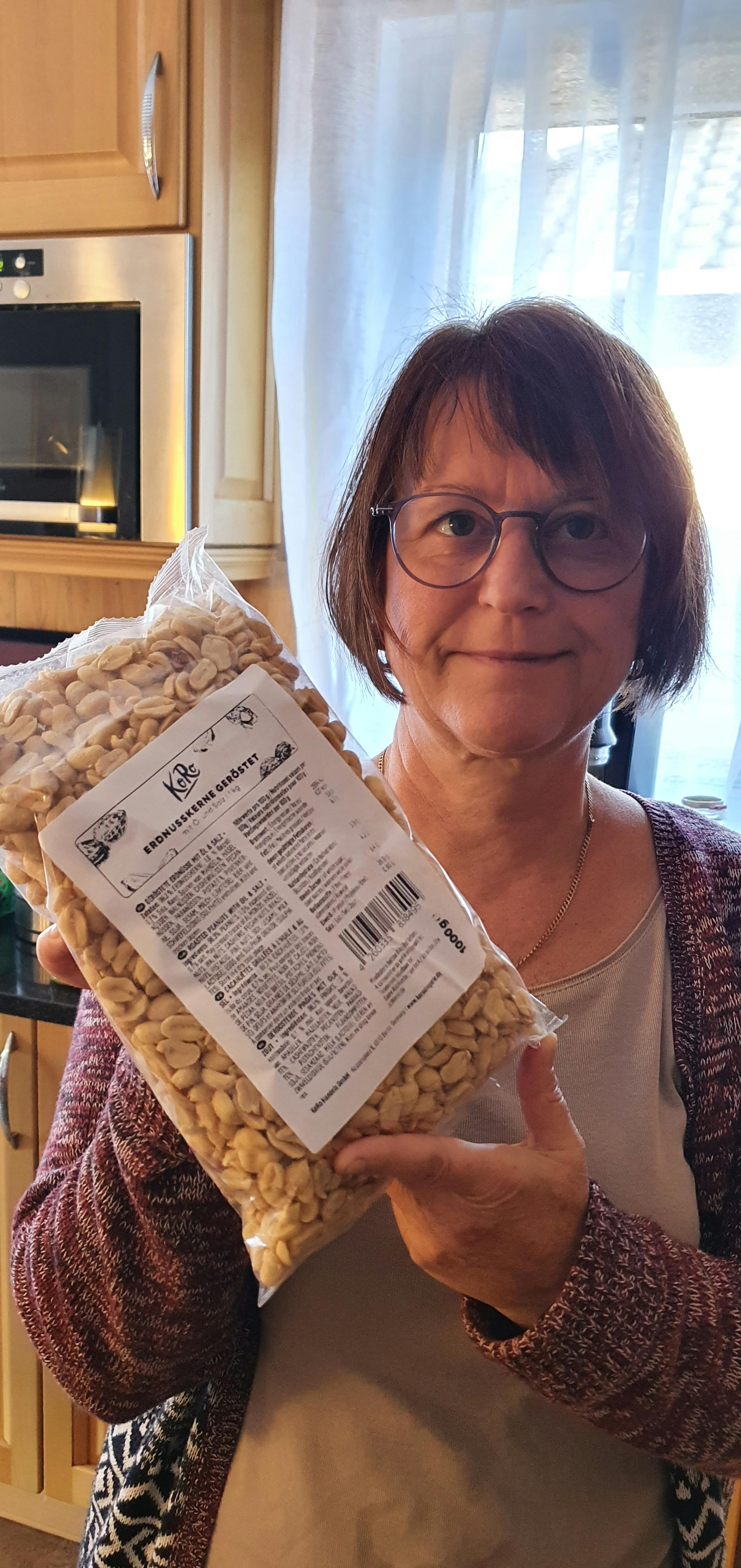 eine frau hält einen sack erdnüsse in ihren händen