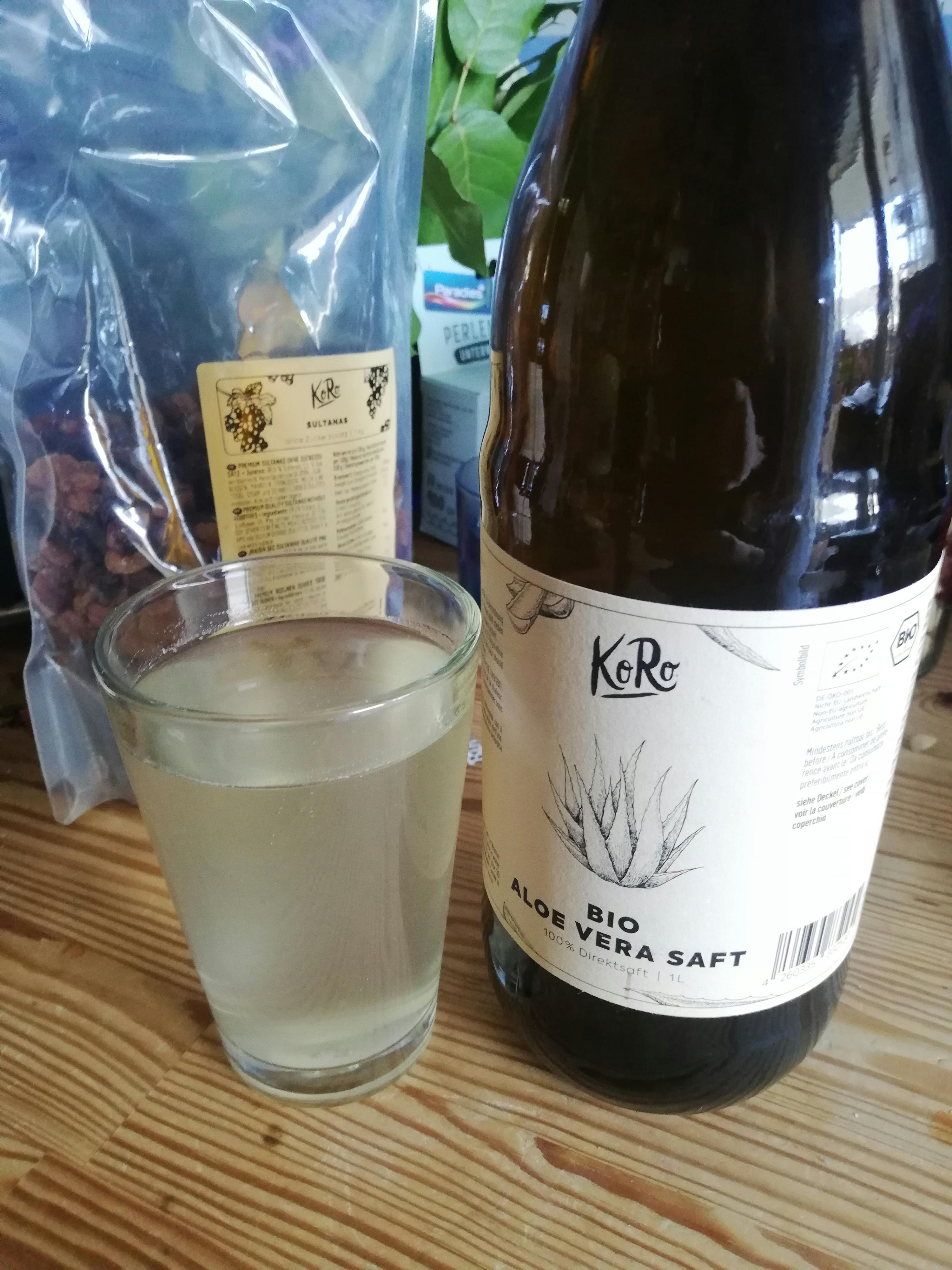 a bottle of bio aloe vera saft next to a glass of it