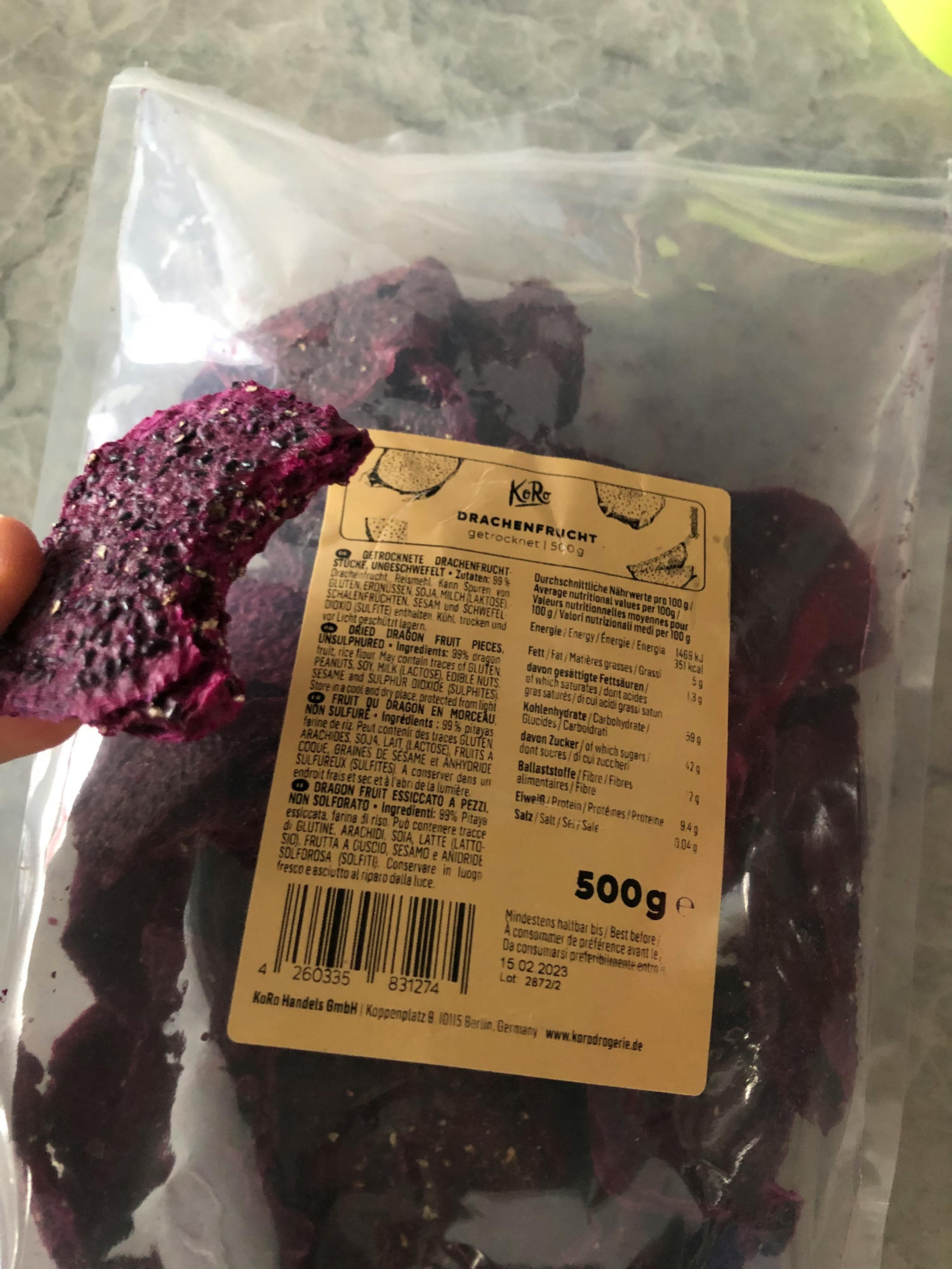 a person is holding a bag of dried dragon fruit chips