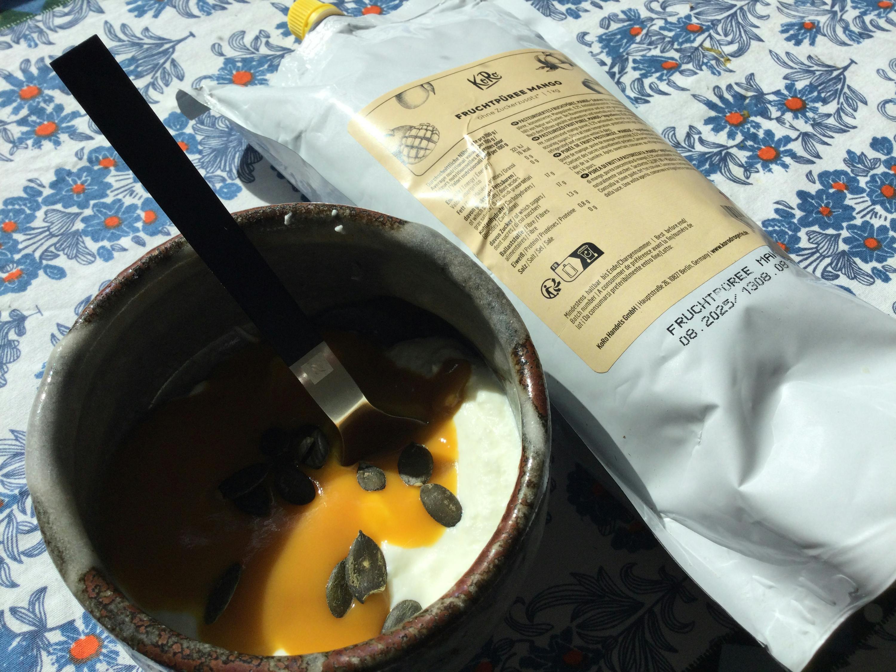 a bowl of yogurt next to a bag of fruchtfreie brand