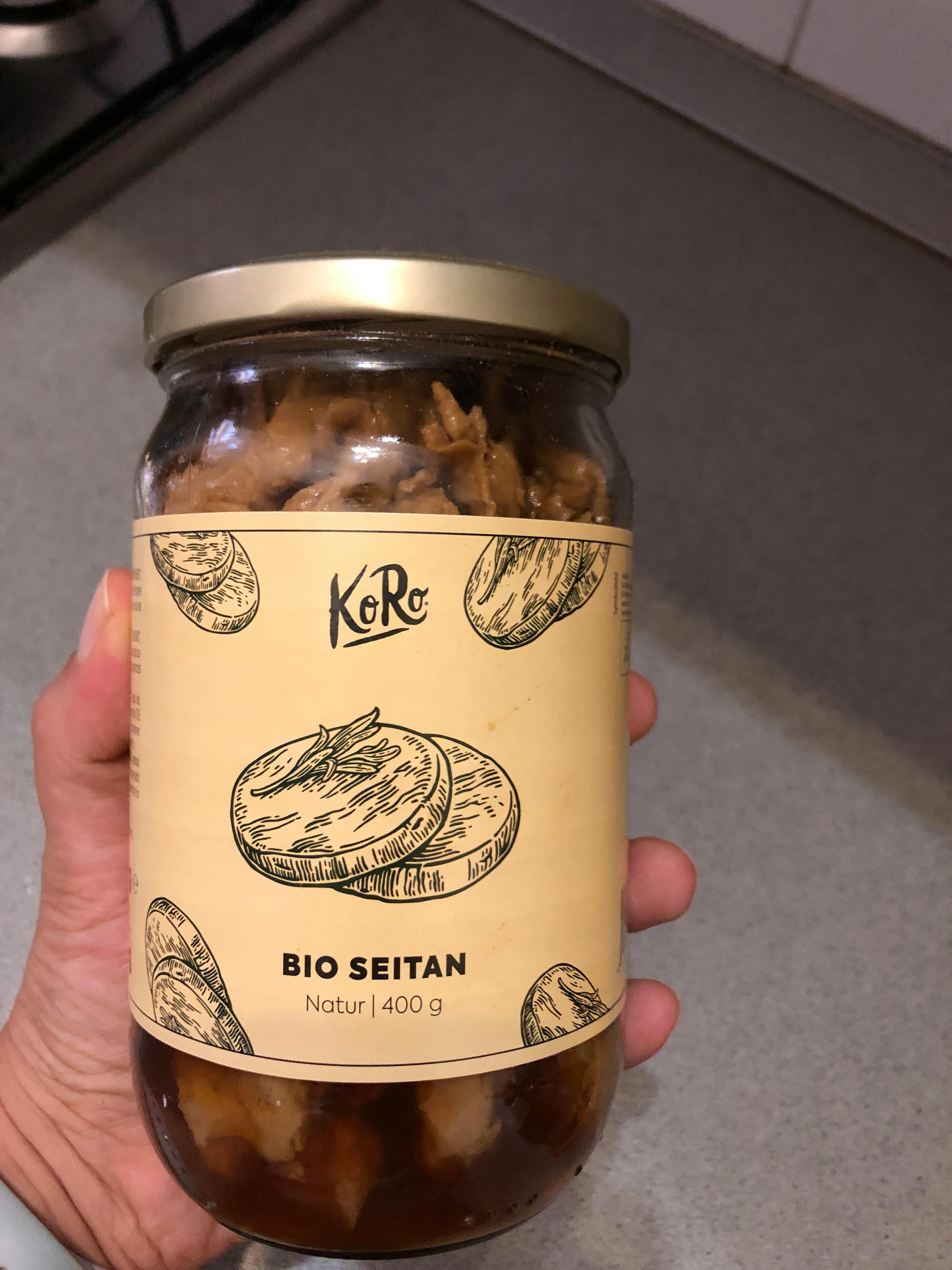 una persona tiene in mano un barattolo di cibo bio seitan