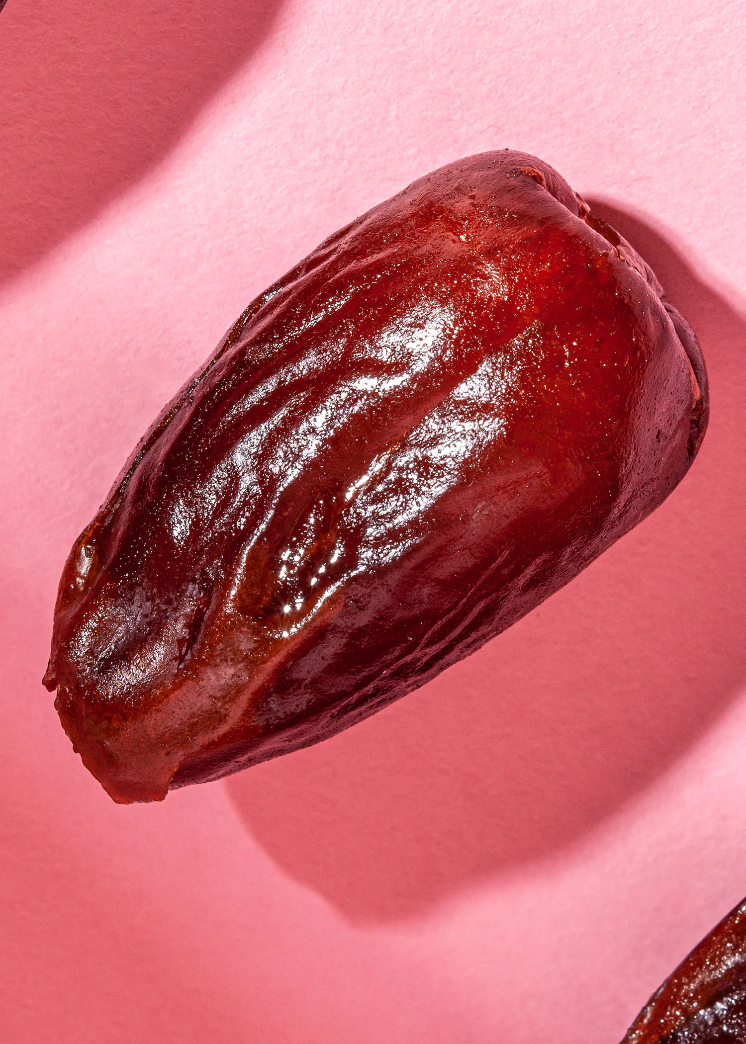 un gros plan d' une datte sur un fond rose
