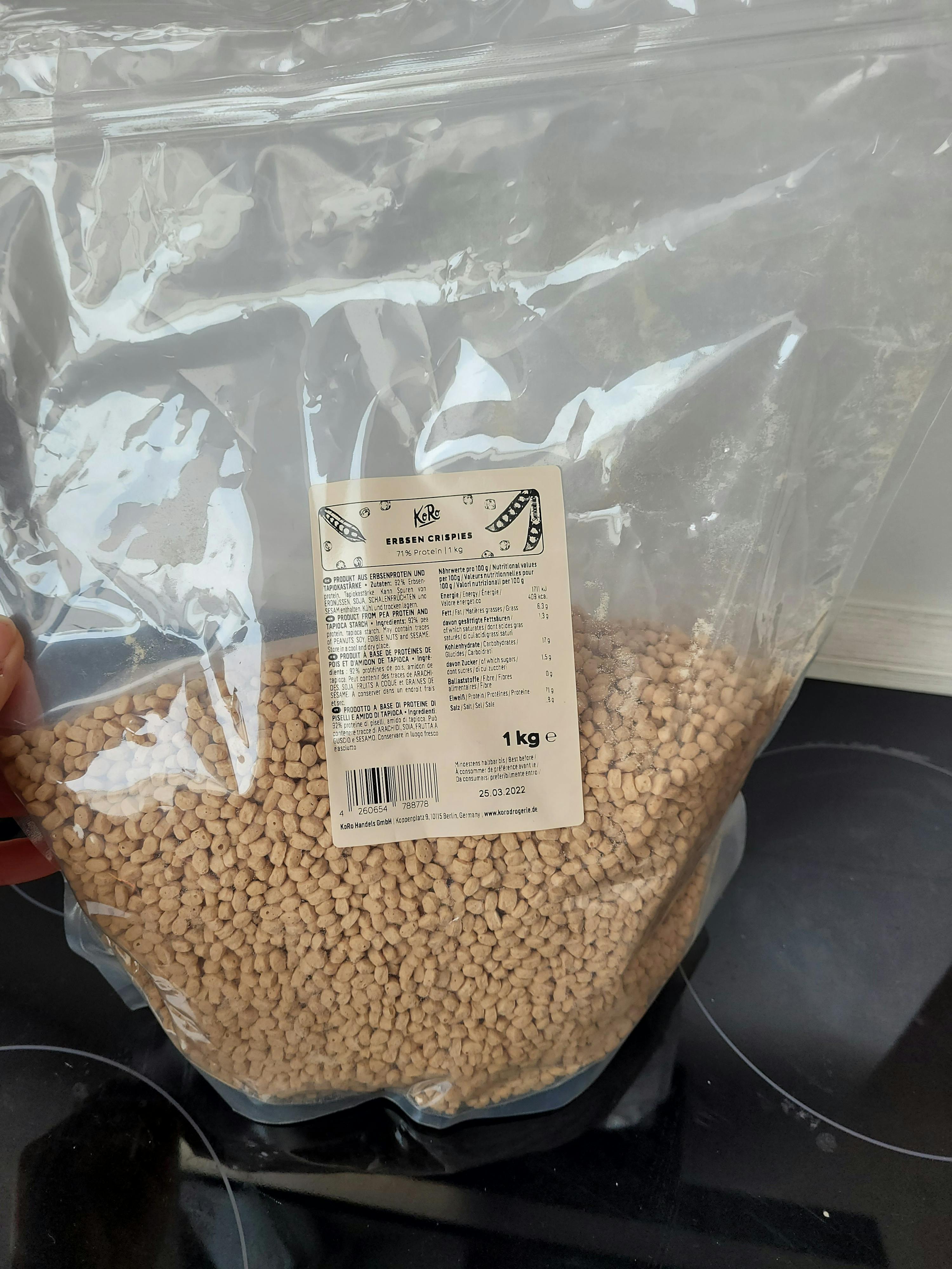 une personne tient un sac en plastique rempli de granulés marrons