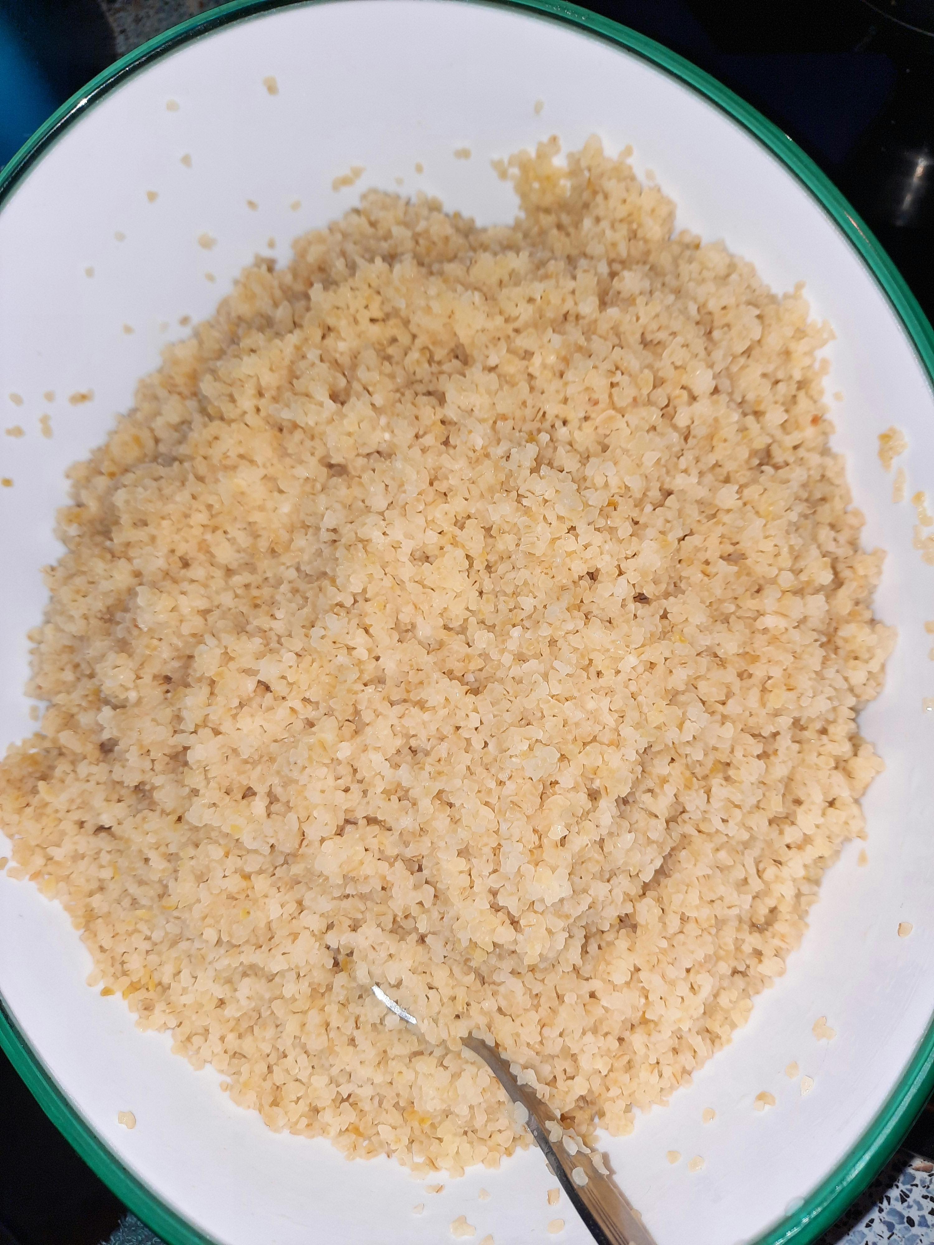 ein weißer Teller mit einem grünen Rand und einem Löffel darin