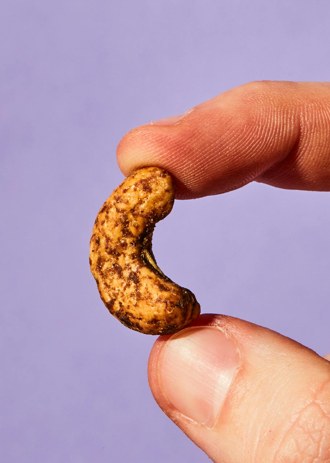 un primo piano di una persona che tiene in mano un anacardi