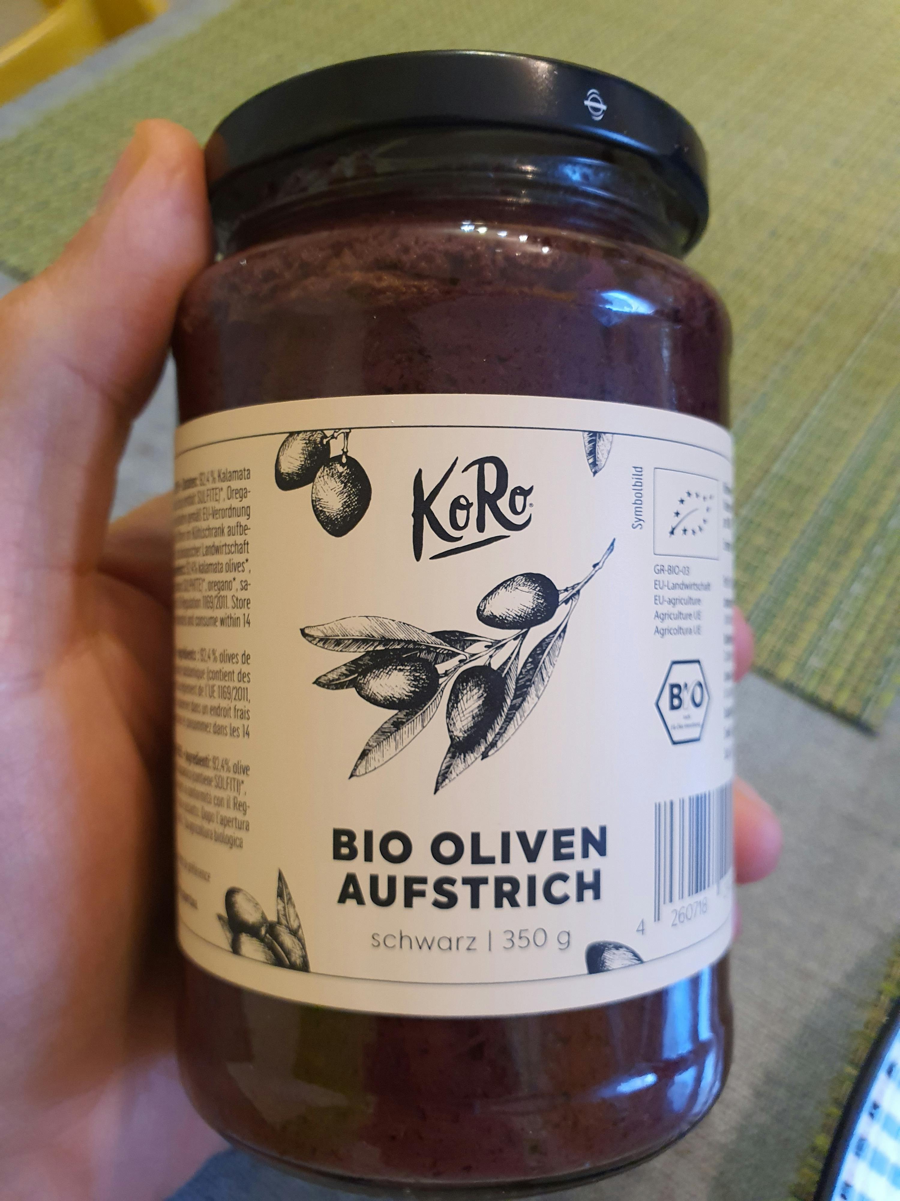 eine Person hält ein Glas Bio-Olivenaufstrich in der Hand