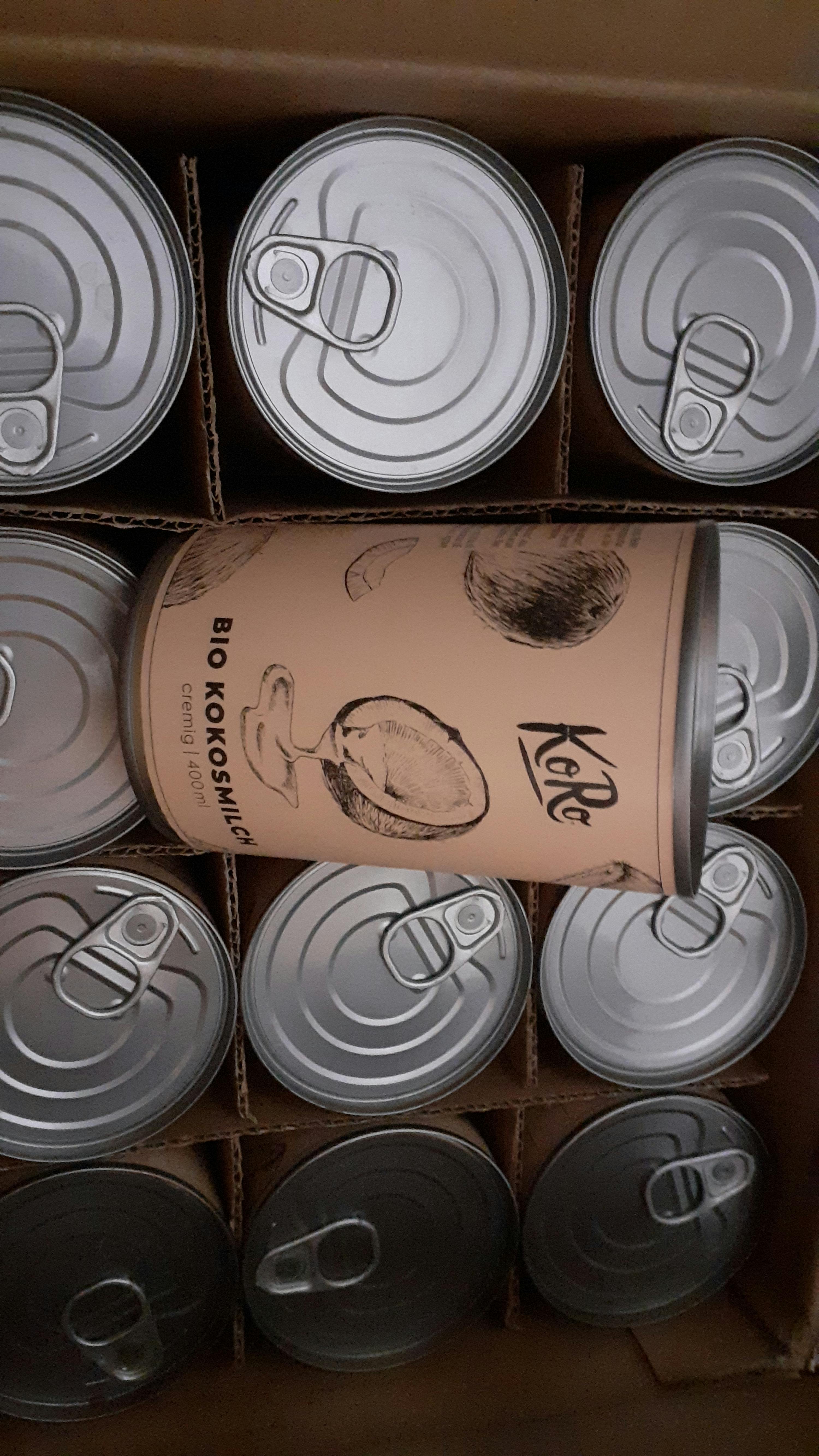 a can of bio kokosmilch is surrounded by other cans