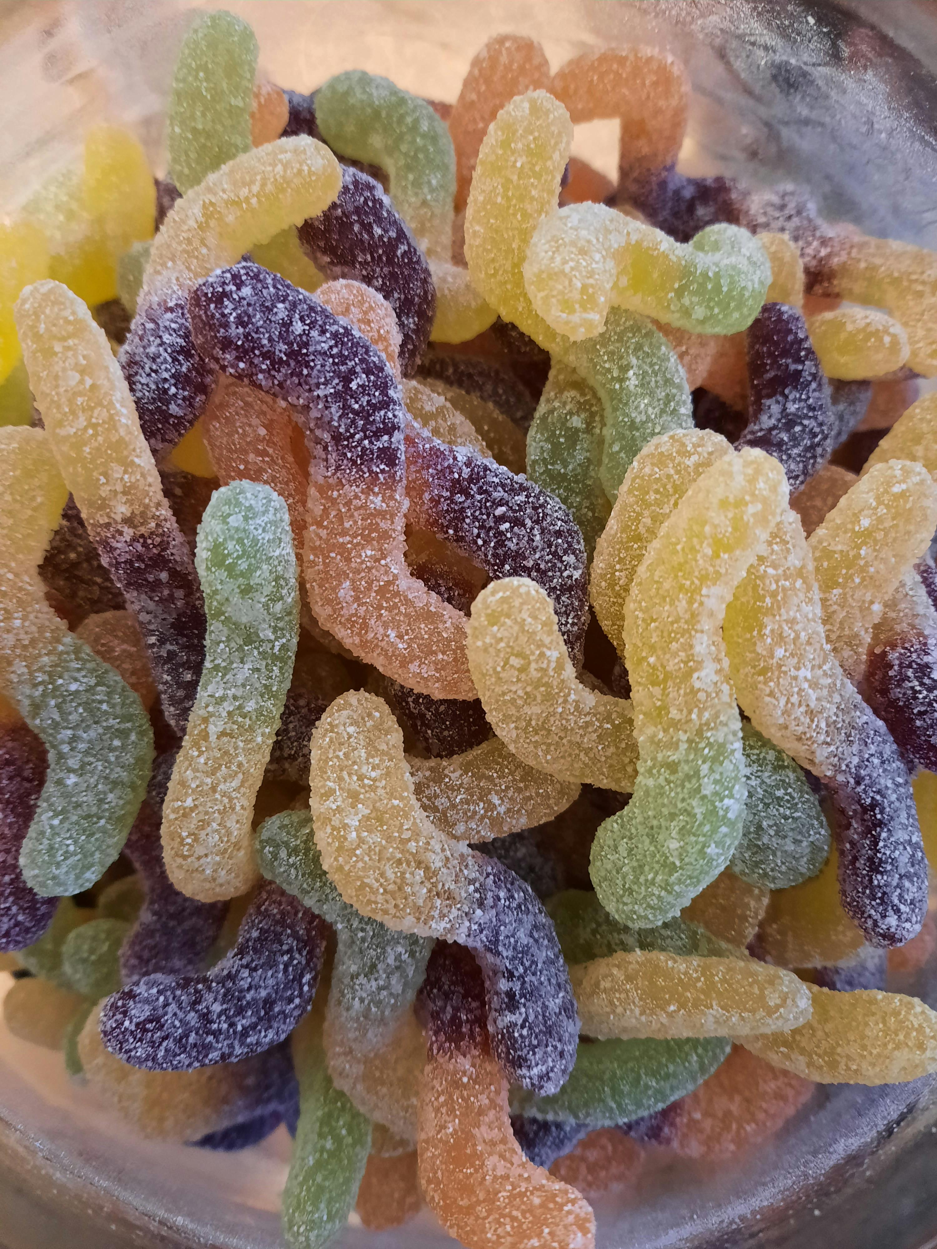 ein Glas mit bunten Gummiwürmern in verschiedenen Geschmacksrichtungen