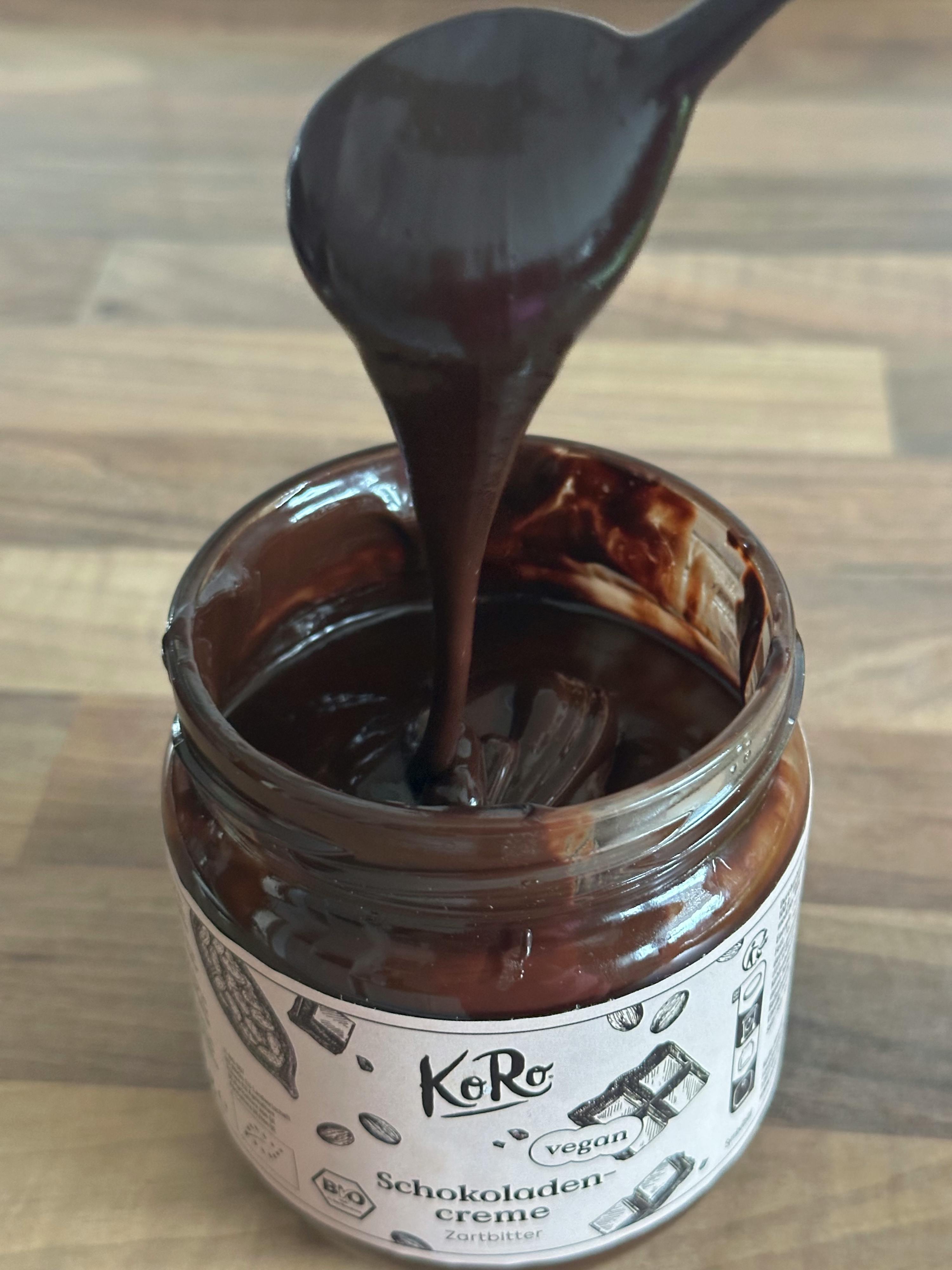 un cucchiaio di cioccolato viene versato da un barattolo di cioccolato