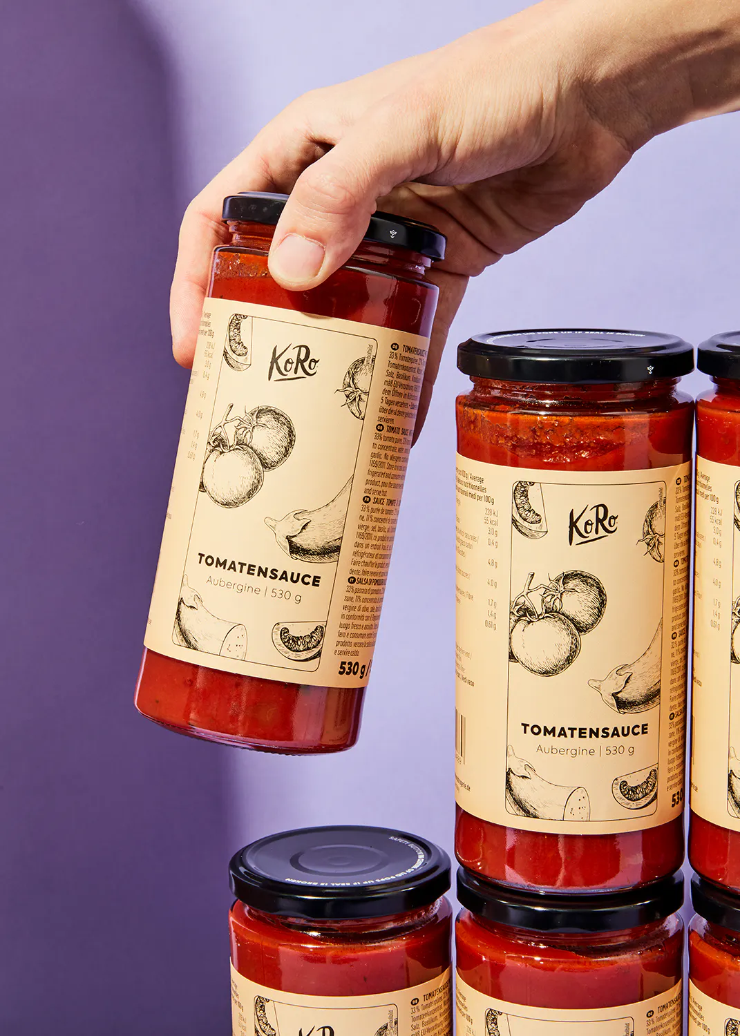 Eine Person hält ein Glas Tomatensauce in der Hand