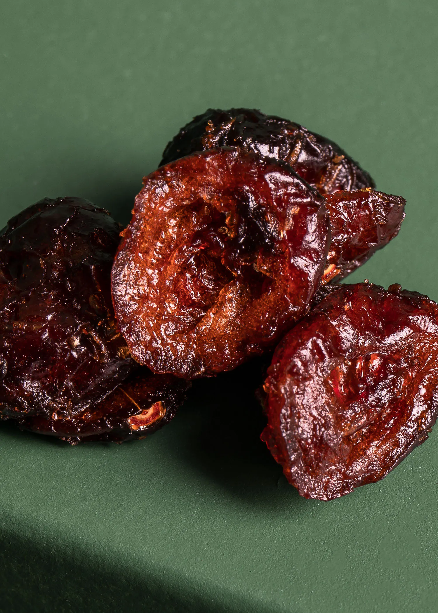 une pile de prunes séchées sur une surface verte