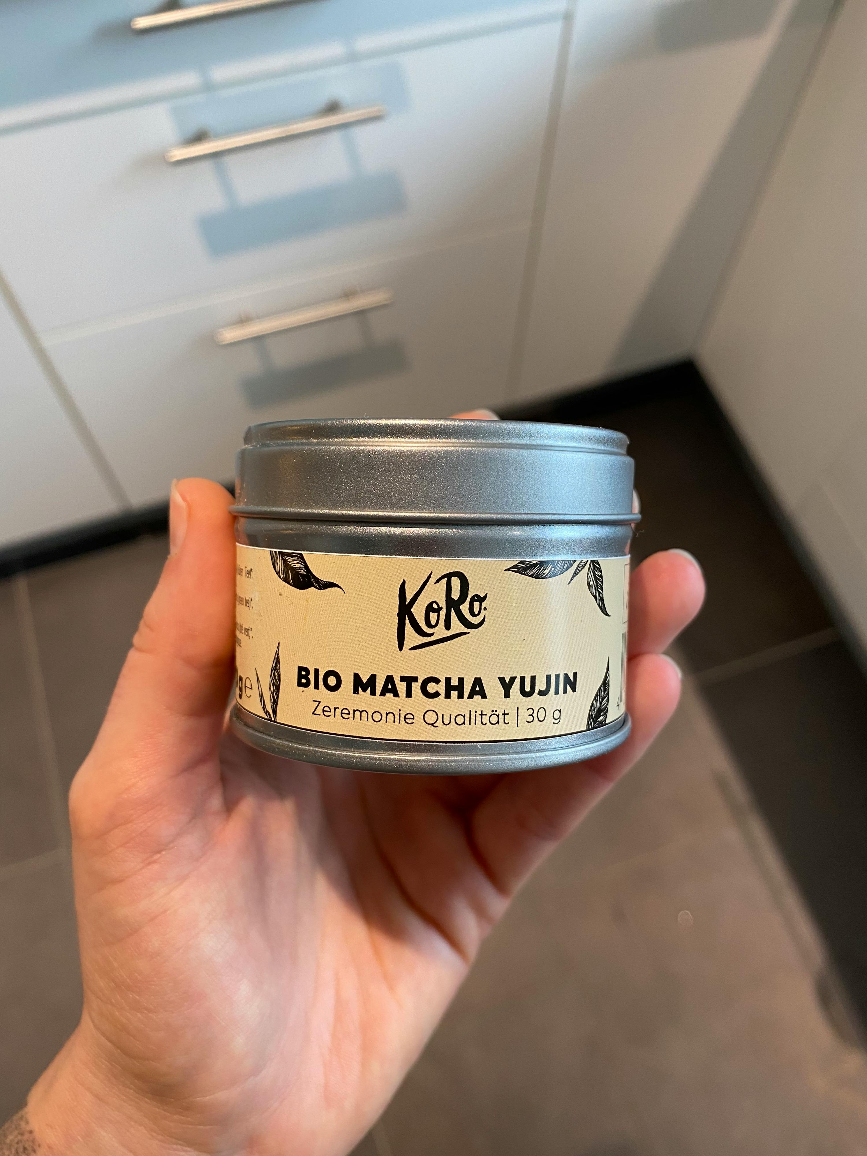 a person holding a can of bio matcha yujin