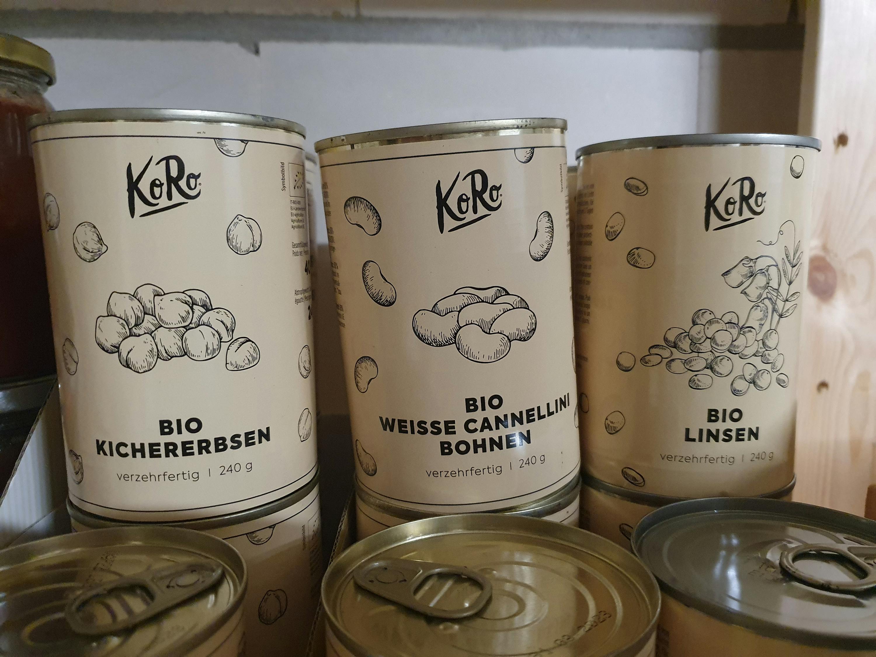 eine Reihe von Dosen mit verschiedenen Produkten von koro