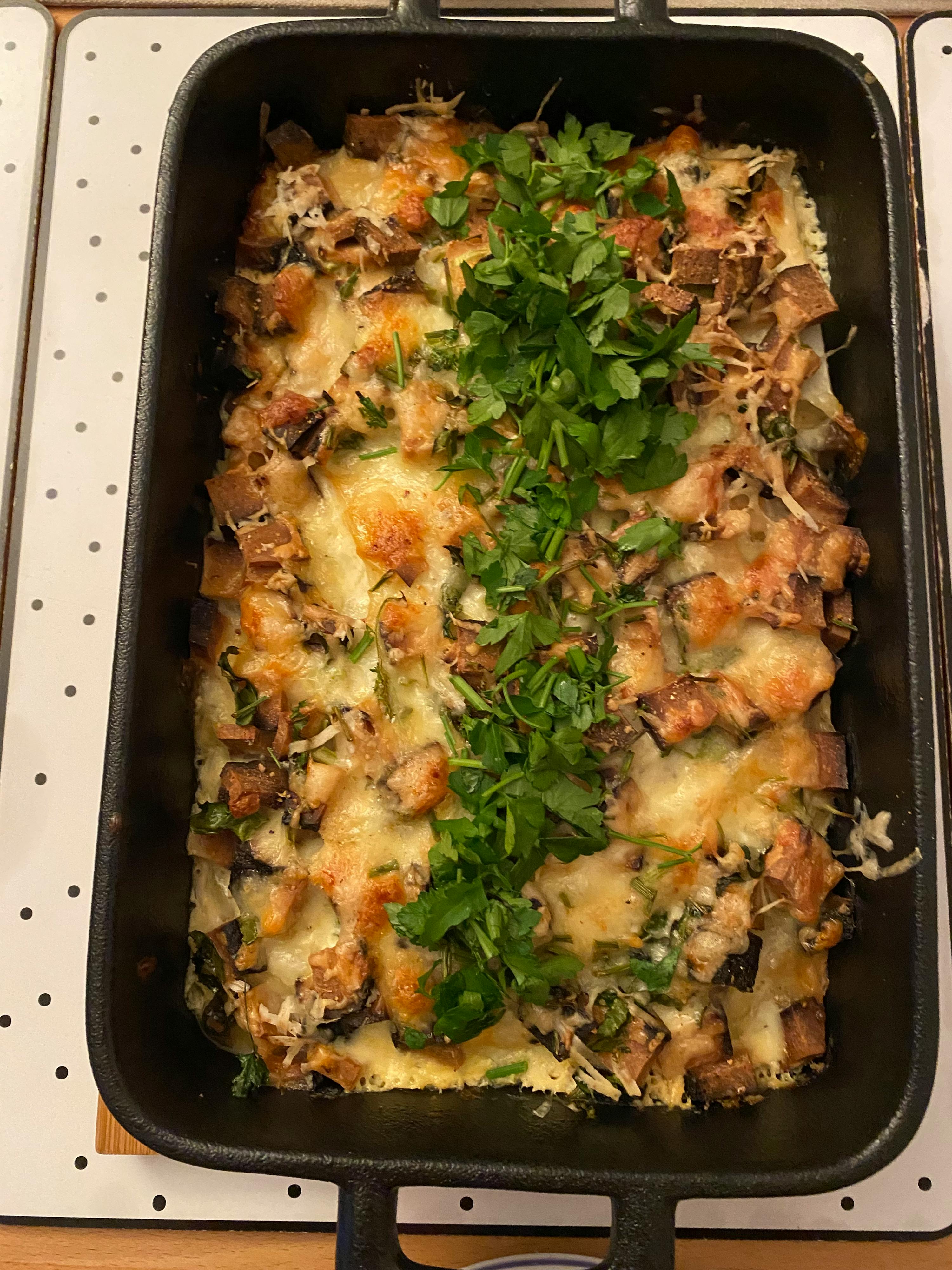 Auf einem Tisch steht eine Auflaufform mit Gemüse und Käse