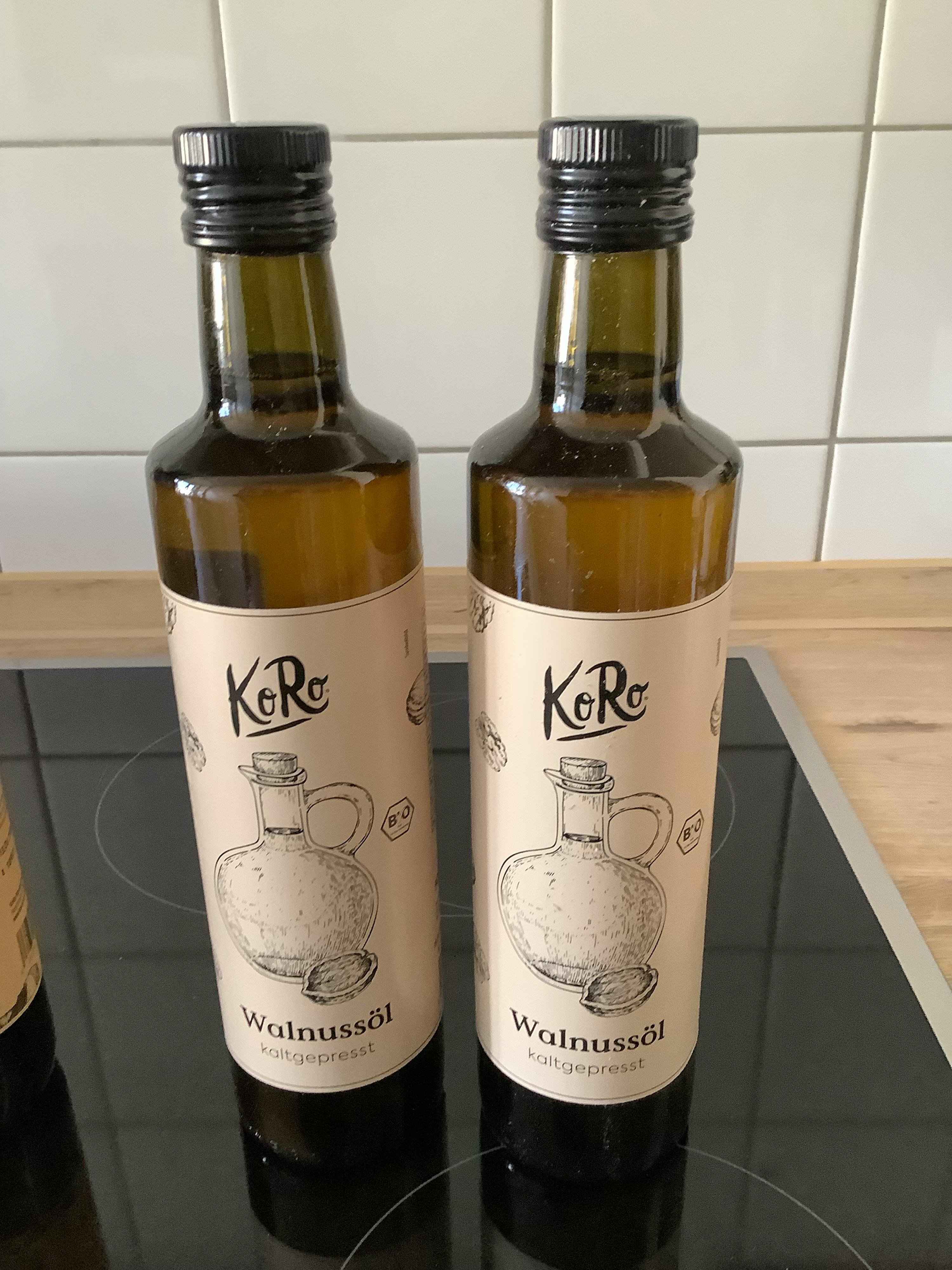 two bottles of walnut oil are sitting on a counter