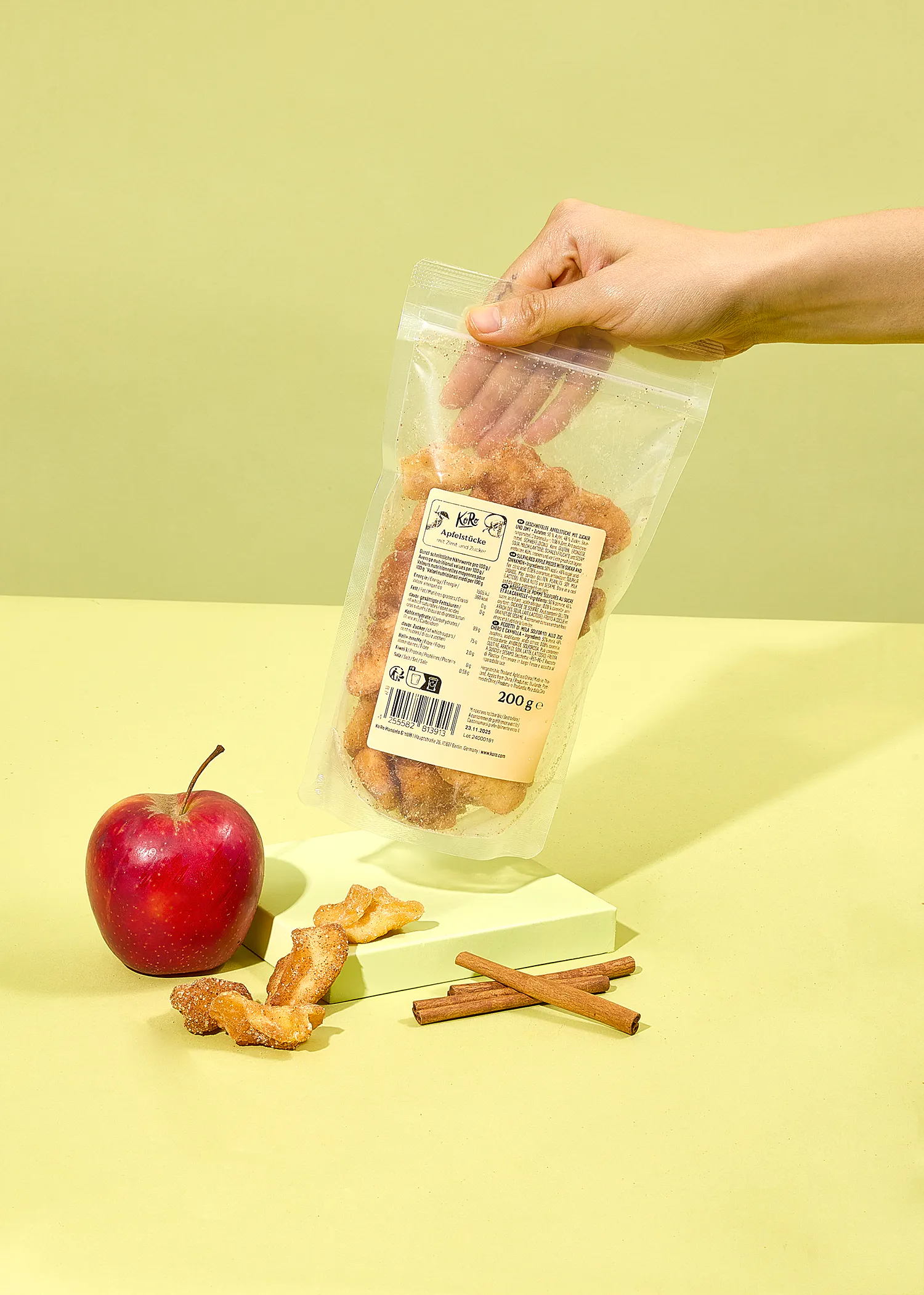 eine Person hält einen Plastikbeutel mit getrockneten Äpfeln in der Hand