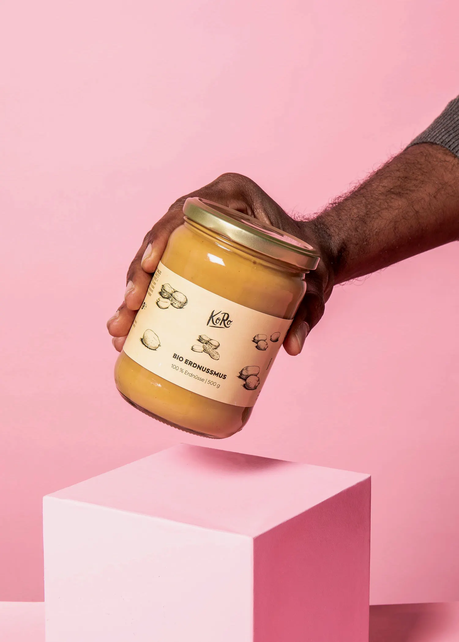 eine Person hält ein Glas erdnussmus in ihrer Hand