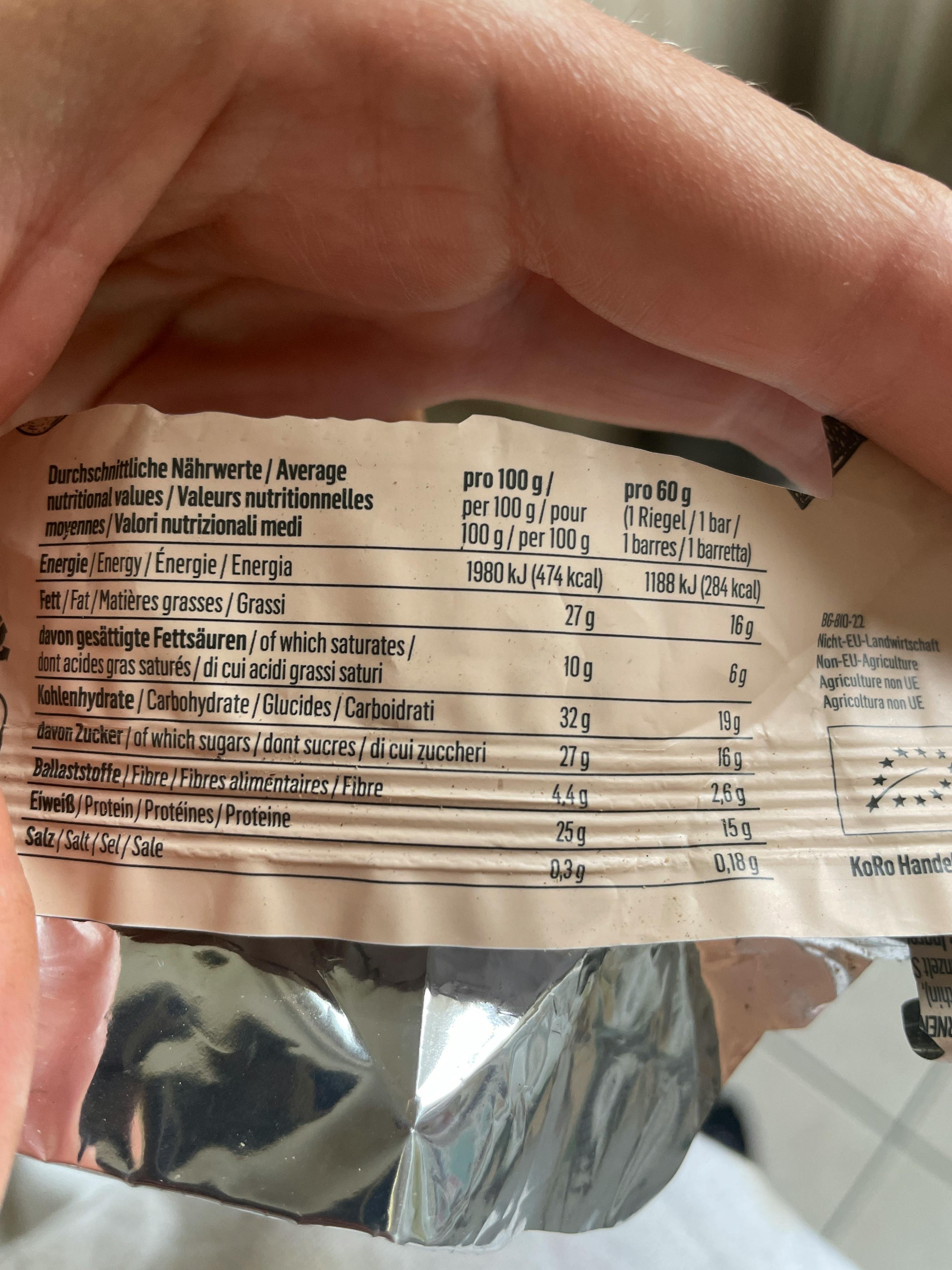 eine Person hält einen Snack mit einer Nährwerttabelle darauf