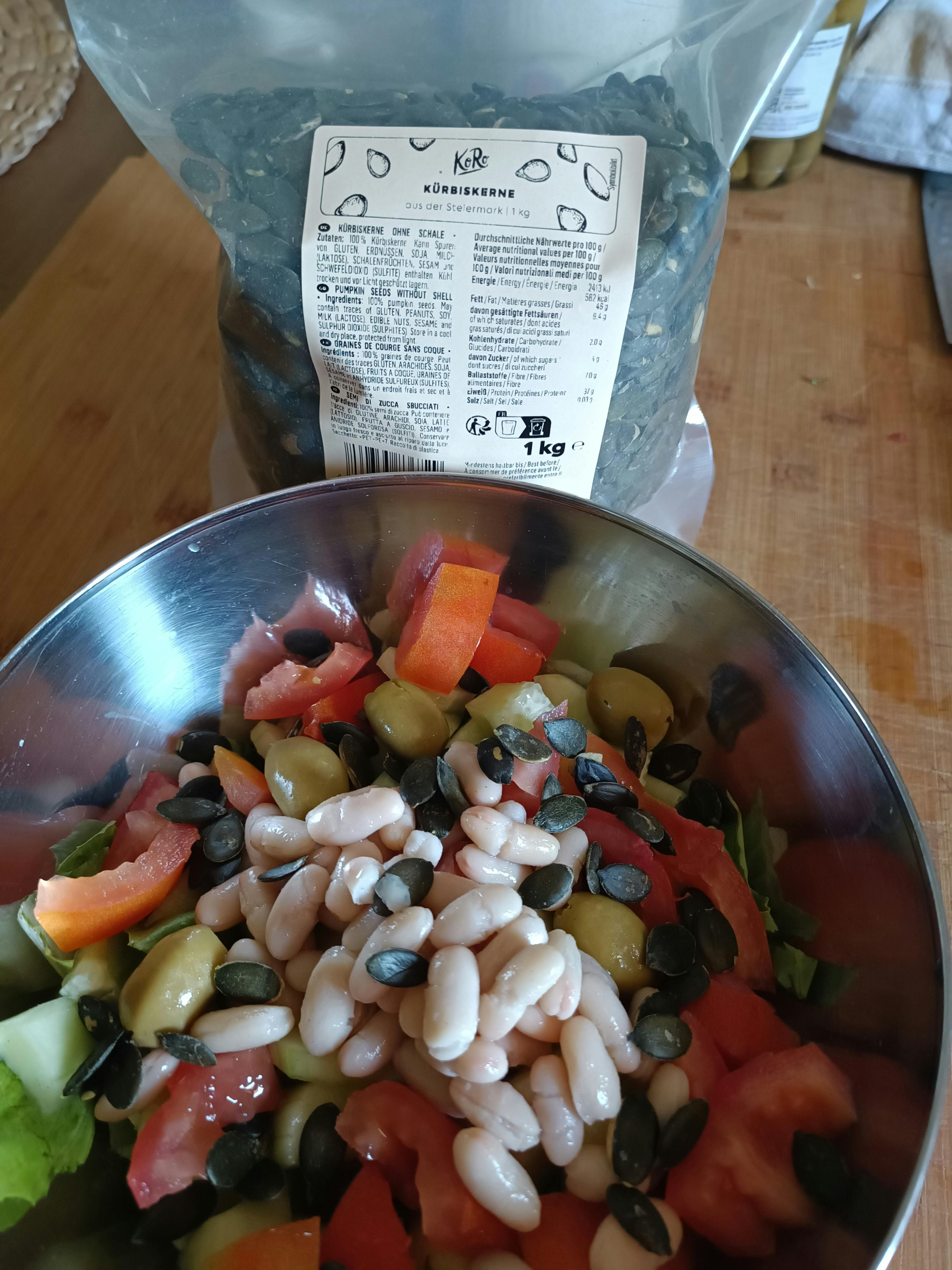 a bowl of beans and vegetables next to a bag of beans