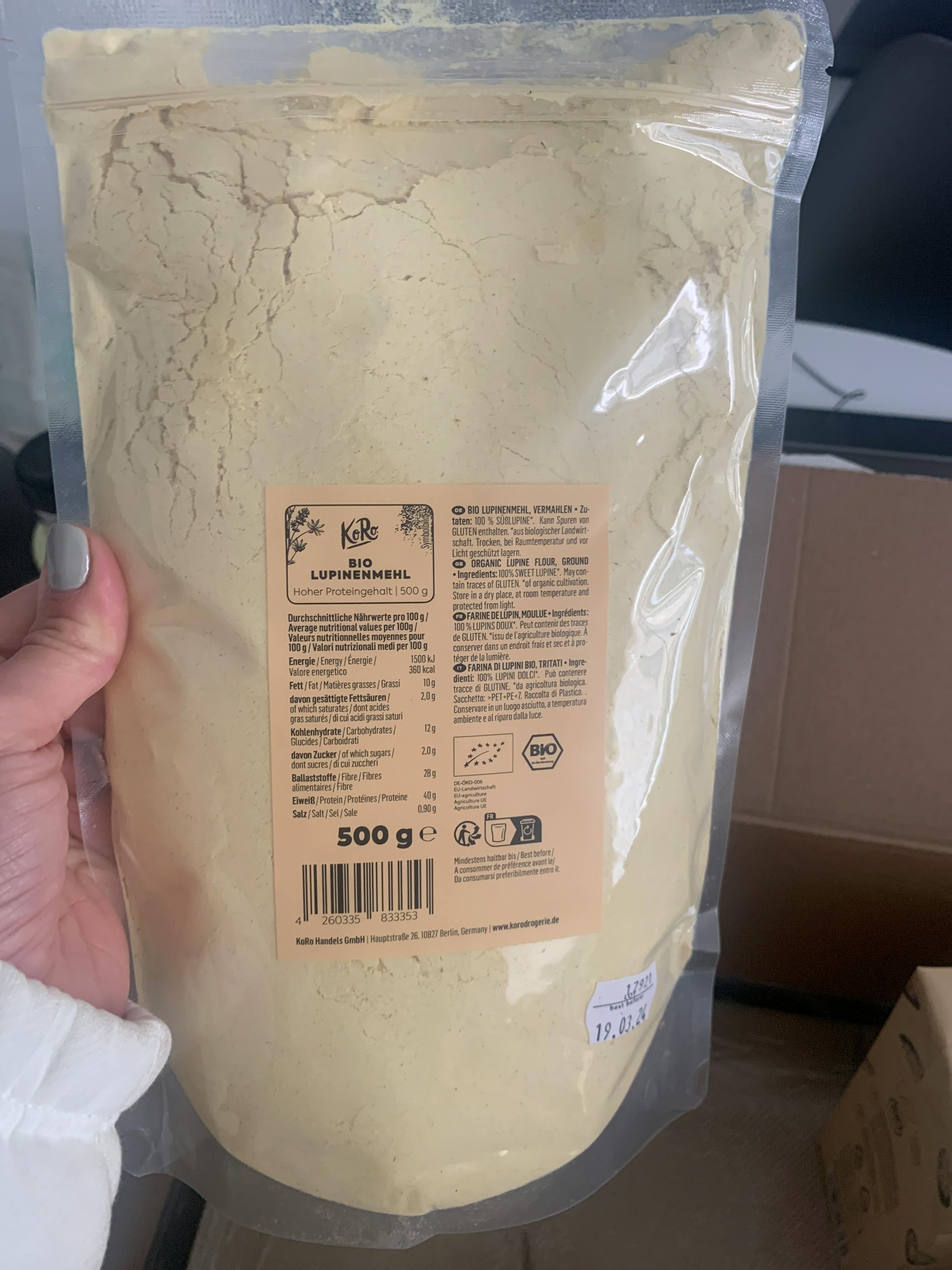 une personne tient un sac de farine avec une étiquette orange