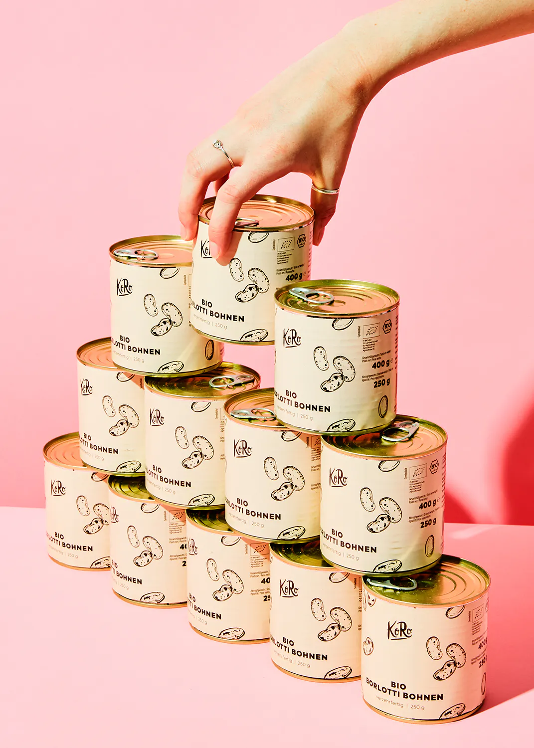 a hand reaches for a can of bio torti bohnen