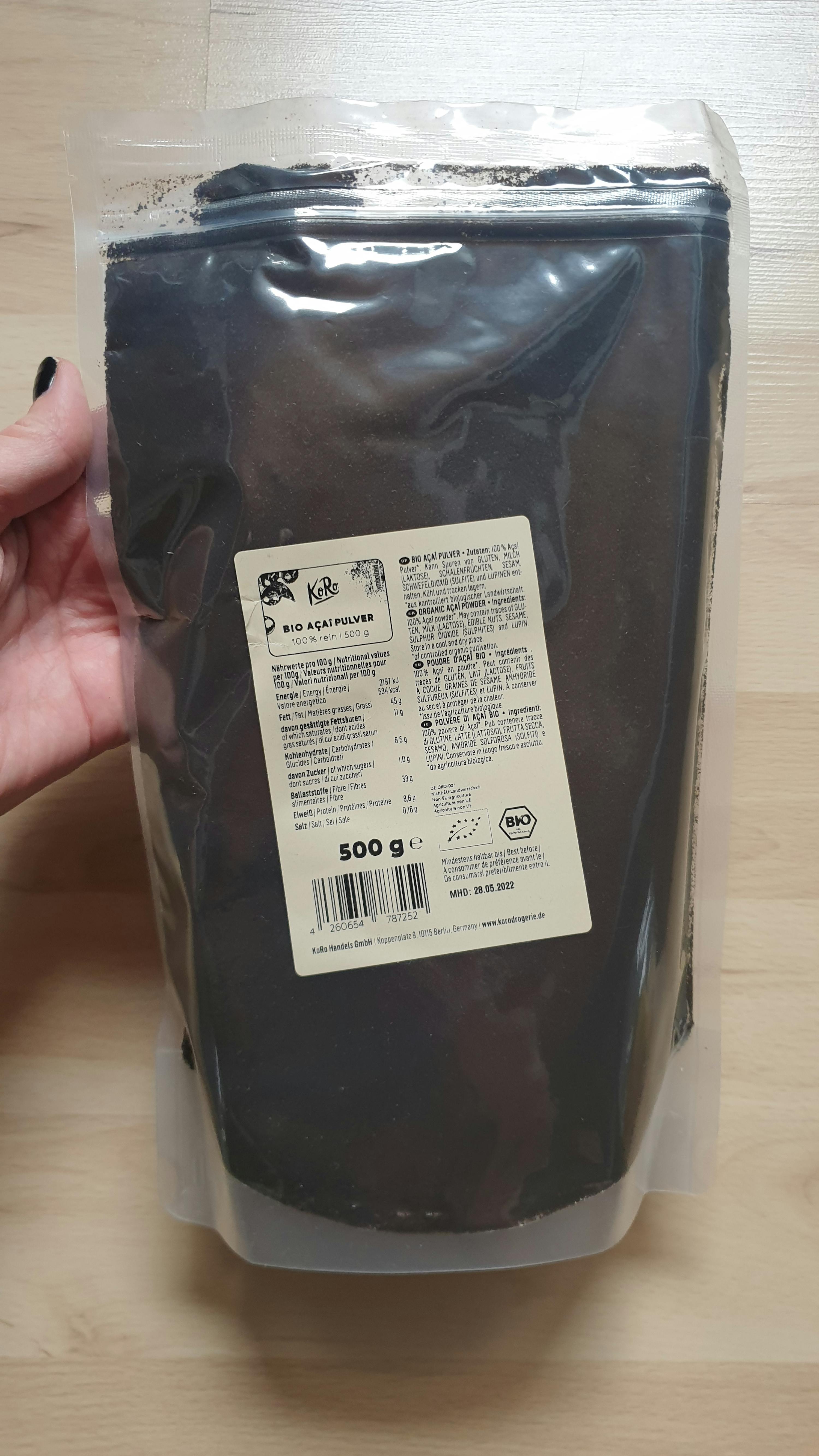 a person holds a bag of cacao powder in their hand